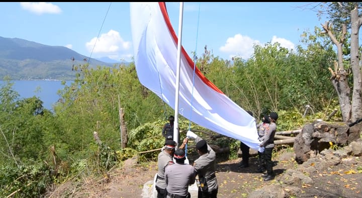 Personel Polres Flores Timur mengibarkan bendera Merah Putih di Bukit Lewonama Postoh, Larantuka, Flotim, NTT.