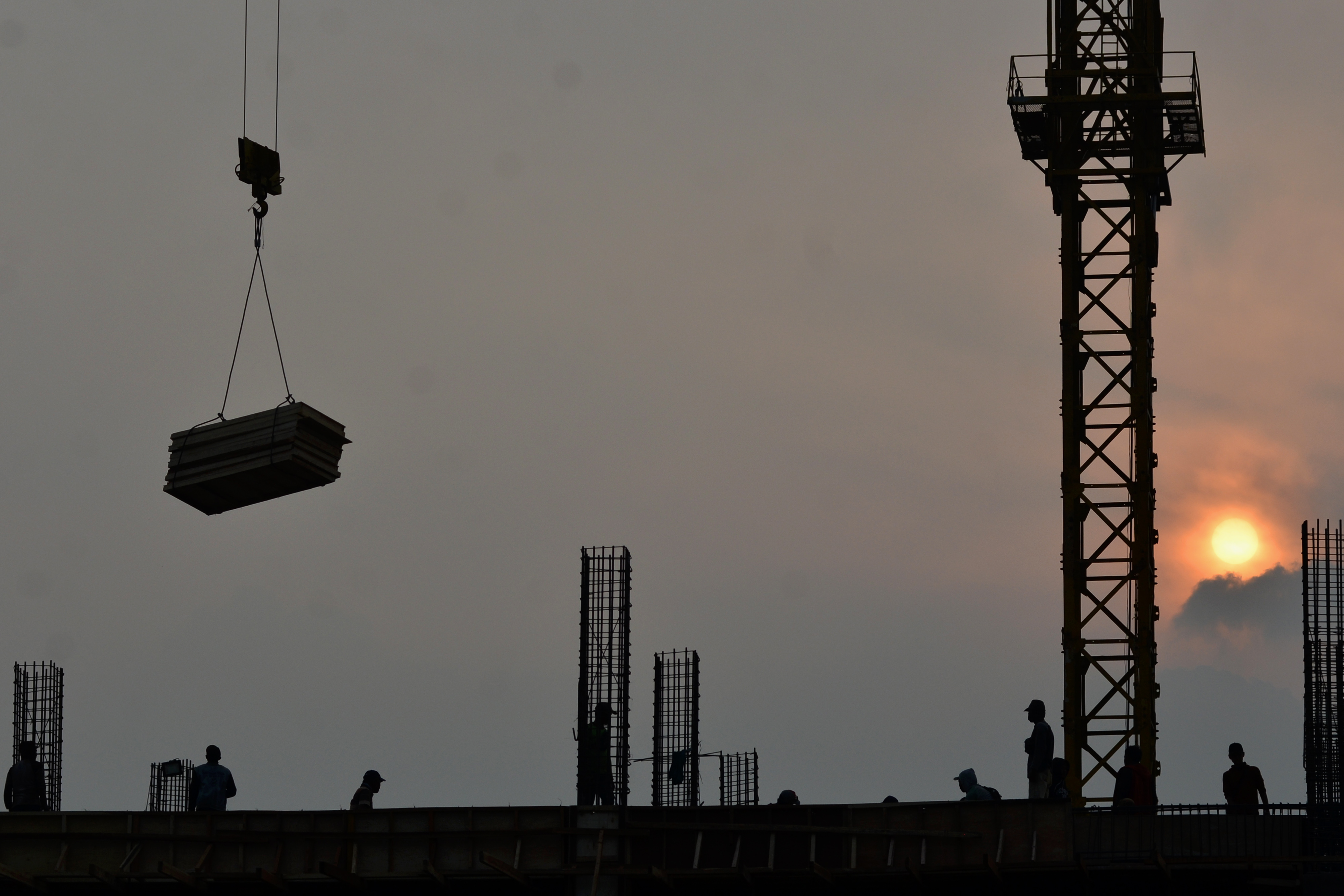 Potret pekerja menyelesaikan pembangunan gedung perkantoran.