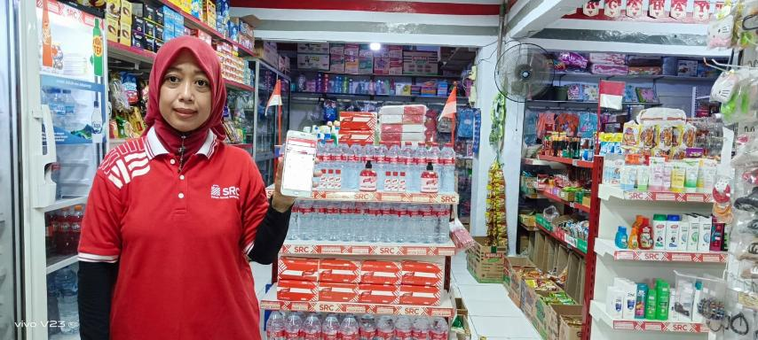 Neneng bersama toko kelontong yang dikelolanya di Cilegon, Banten