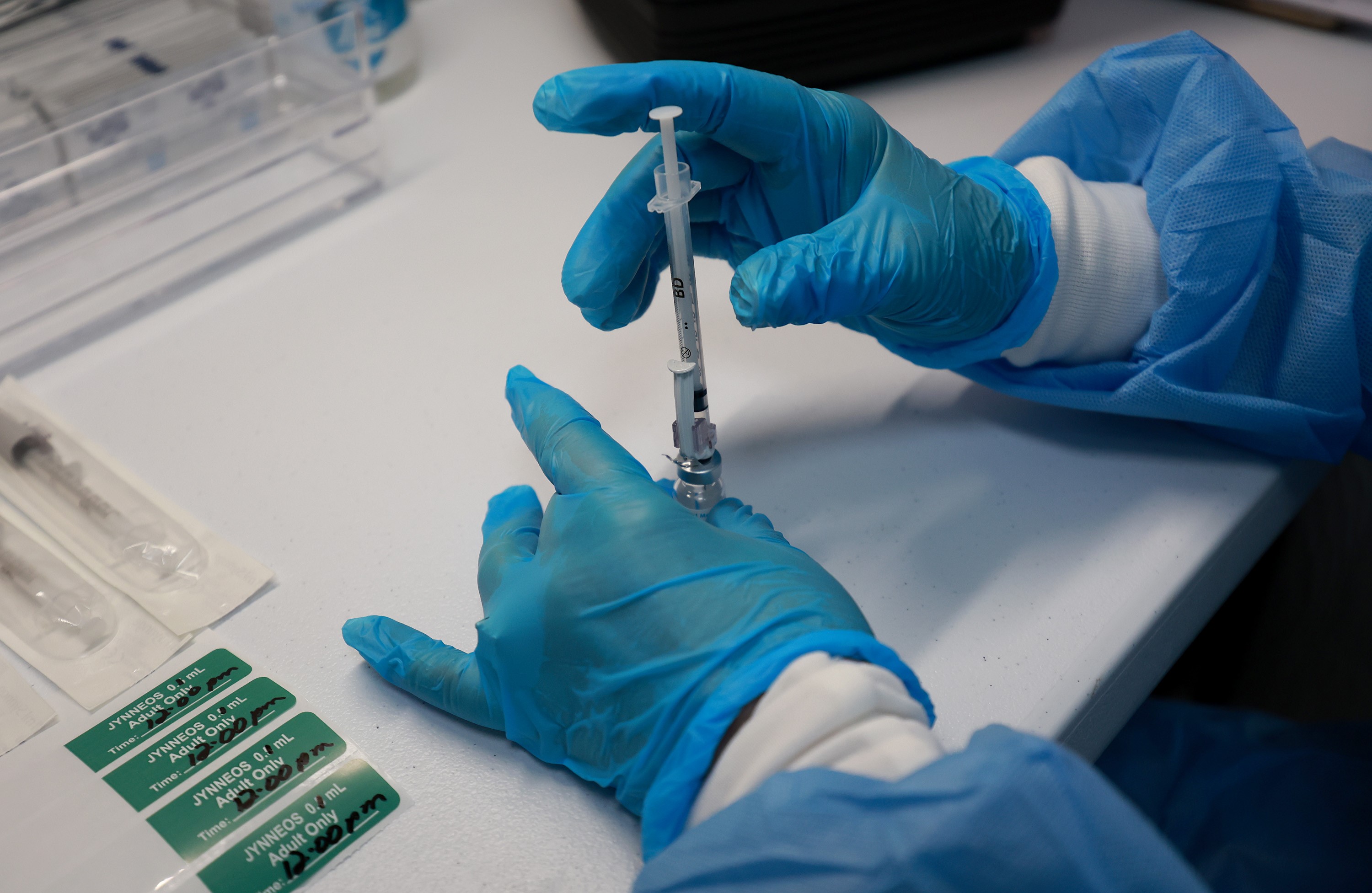 Ilustrasi petugas kesehatan mengukur dosis vaksin monkeypox untuk disuntikkan.