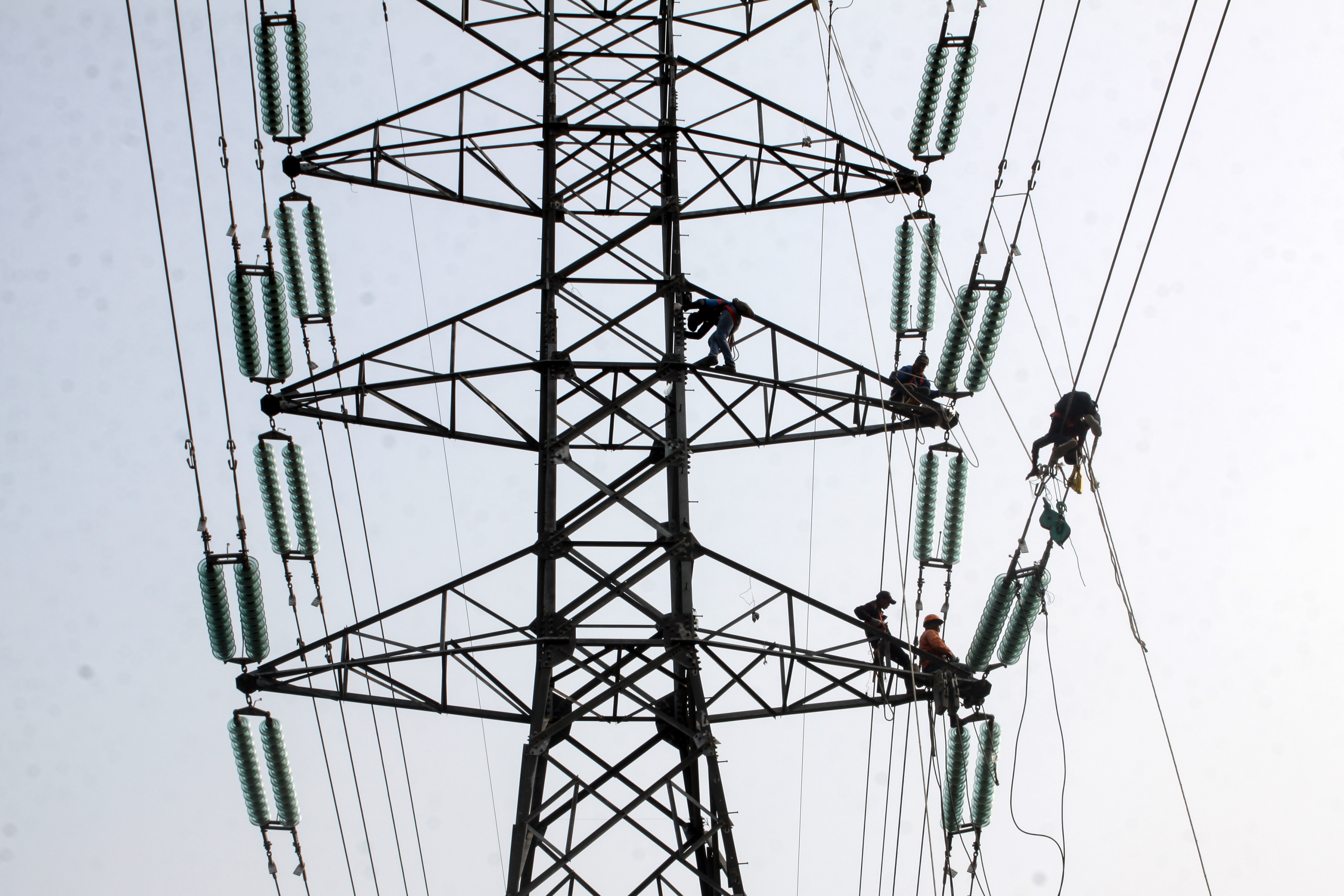 Potret pekerja memasang instalasi listrik di menara SUTET.