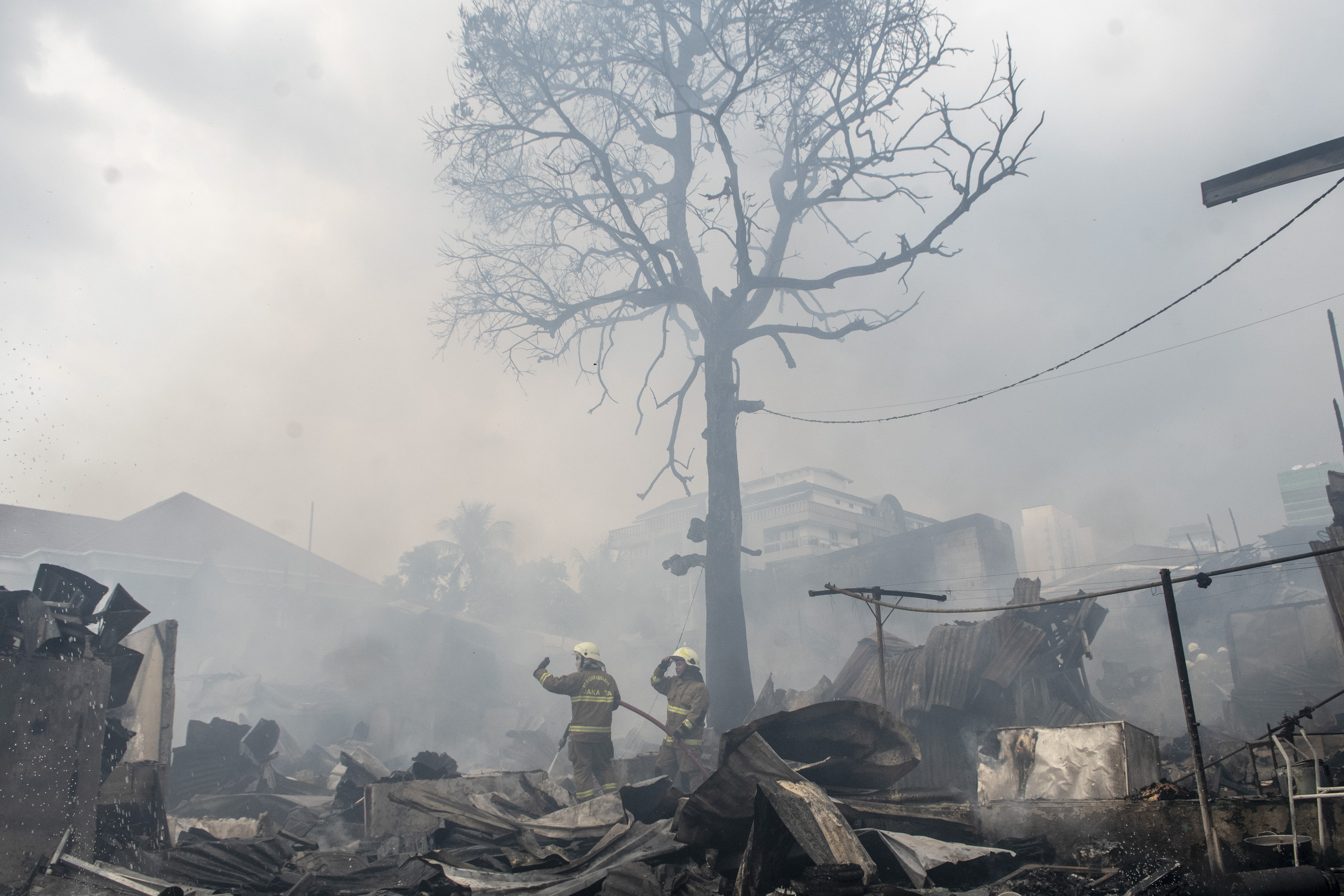  Petugas pemadam kebakaran memadamkan api yang membakar rumah penduduk di kawasan Jalan Simprug Golf Dua, Jakarta, Minggu (21/8).