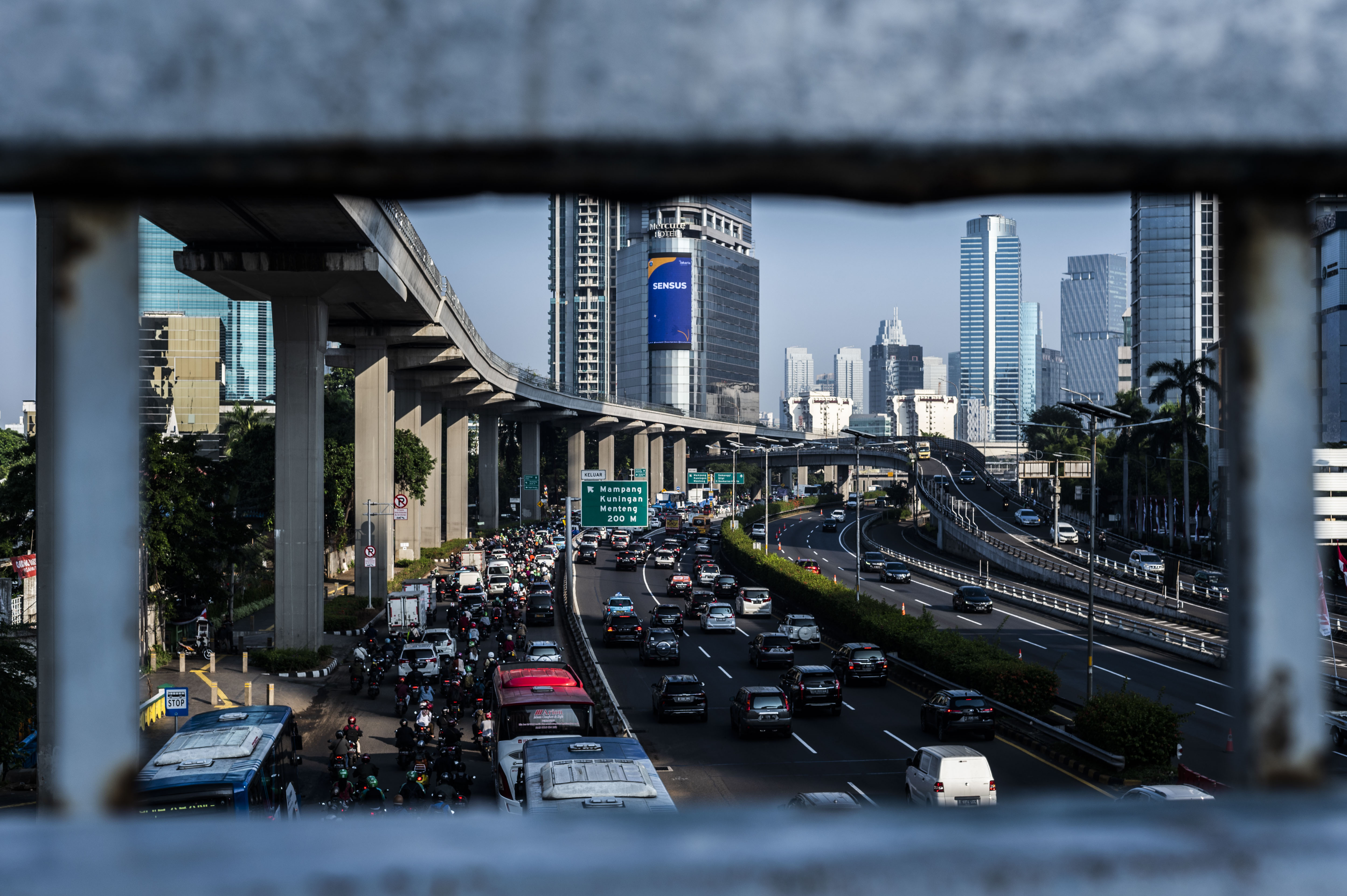 Kendaraan melintas dengan latar belakang gedung bertingkat di Jakarta, Senin (8/8/2022). 