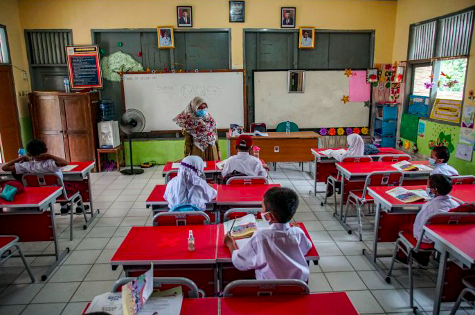 PTM TERBATAS: Sejumlah siswa menyimak pemaparan guru pada hari pertama PTM terbatas di SDN Depok Baru 8, Kota Depok, Jawa Barat. 