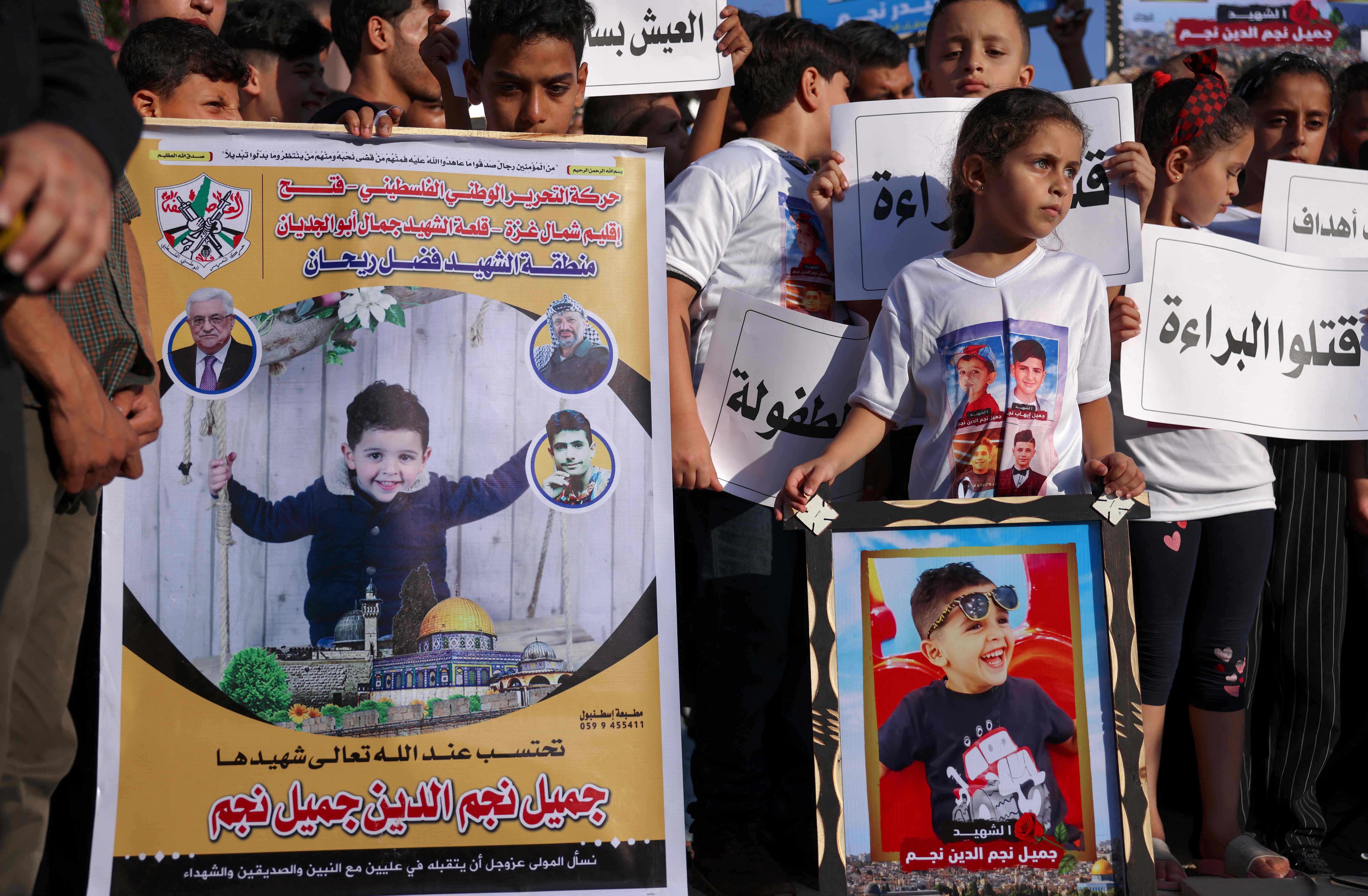 Demonstran membawa foto anak yang tewas dalam gempuran Israel ke Jalur Gaza.