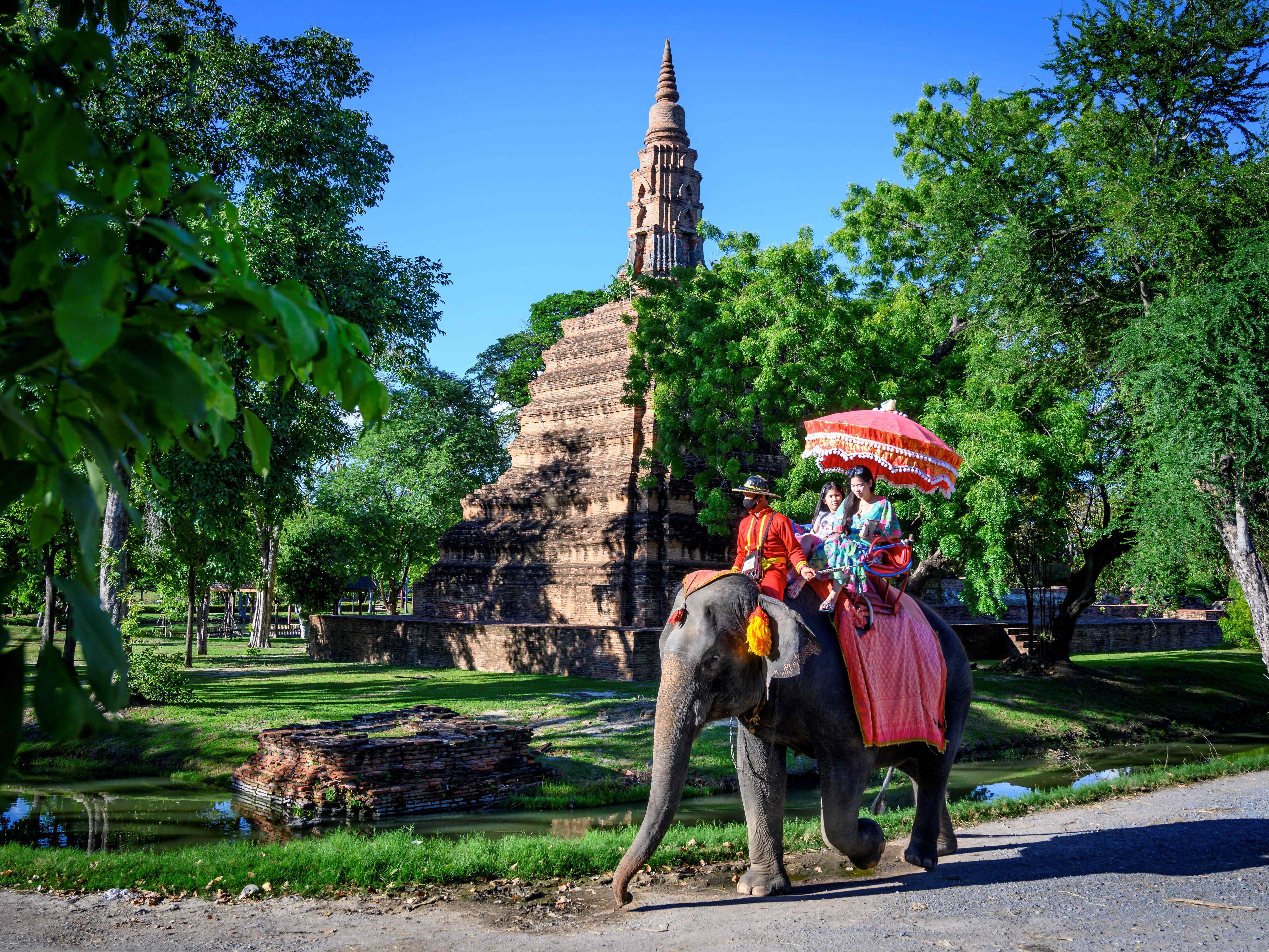 Wisatawan mengendarai gajah di depan kuil Buddha tua di Ayutthaya, sekitar 70 km utara Bangkok. 