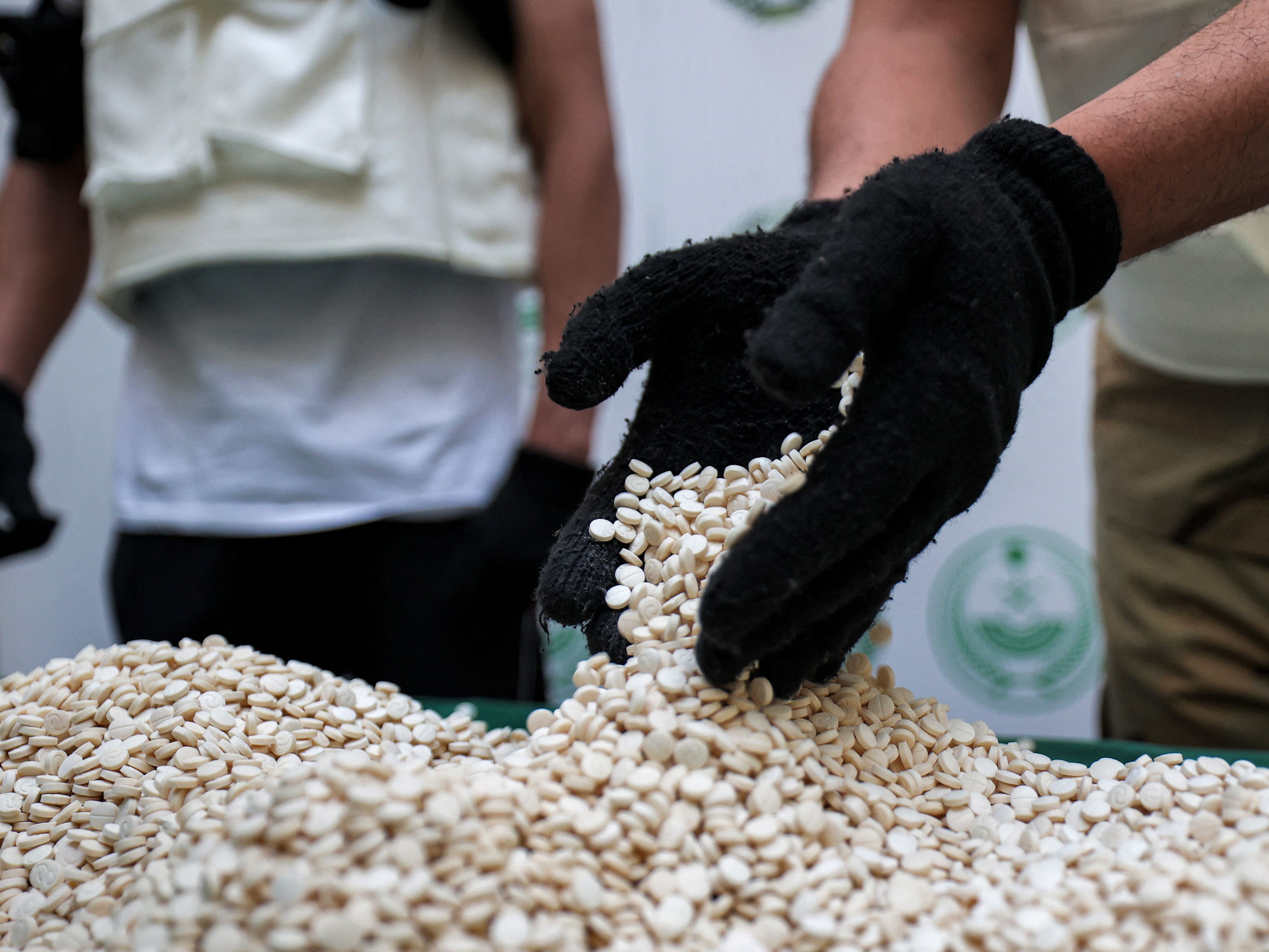 Petugas Direktorat Pengawasan Narkotika Kementerian Dalam Negeri Arab Saudi memilah tablet captagon yang disita selama operasi.