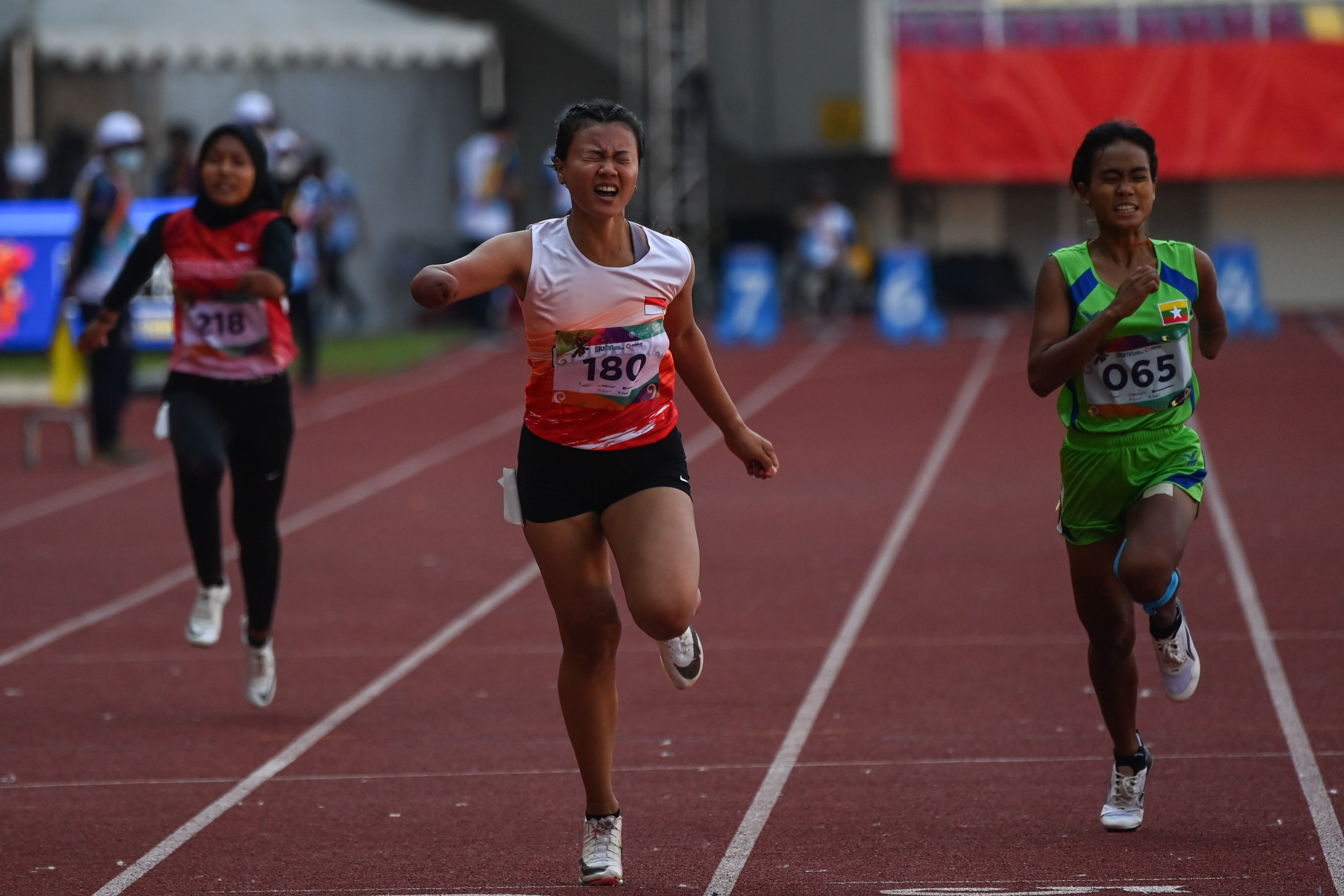 Pelari Indonesia Nanda Mei Sholihah (tengah) beradu cepat saat tampil di nomor lari 100 meter T46/47 di Stadion Manahan Solo, Senin (1/8).