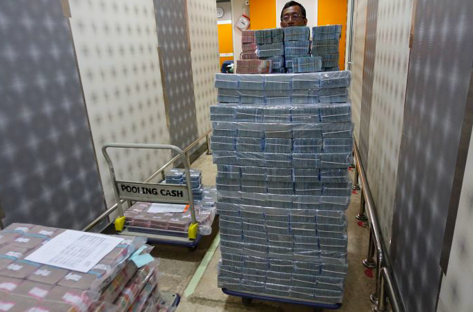 Pekerja membawa uang rupiah di cash center Bank Mandiri, Jakarta, Selasa (27/9).