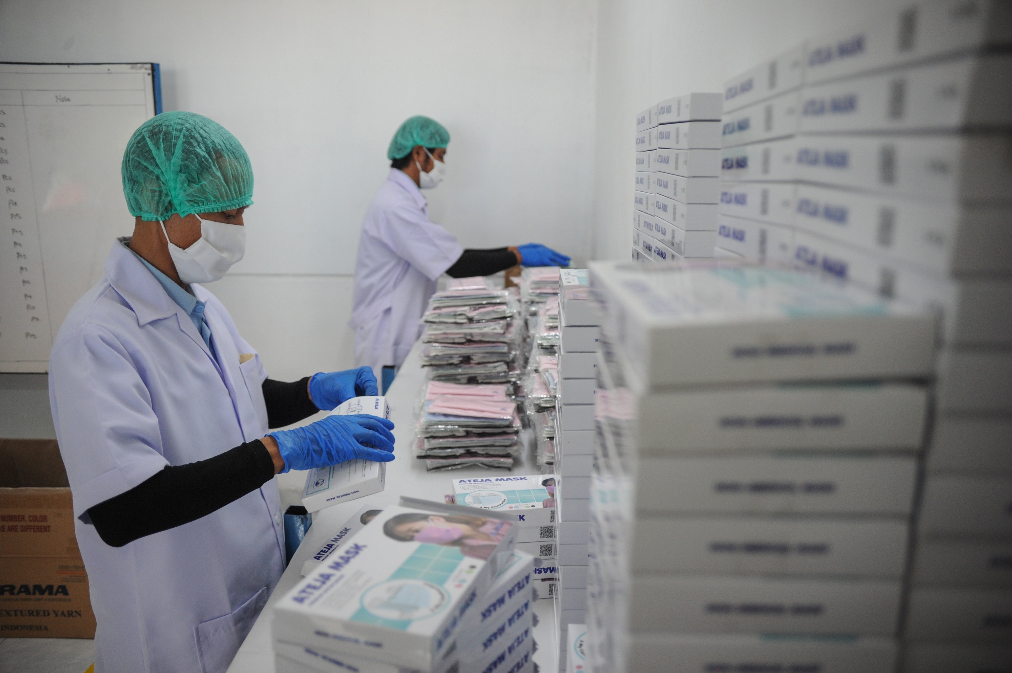 Pekerja melakukan pengemasan saat memproduksi masker kain Ateja di Pabrik Ateja, Batujajar, Kabupaten Bandung Barat