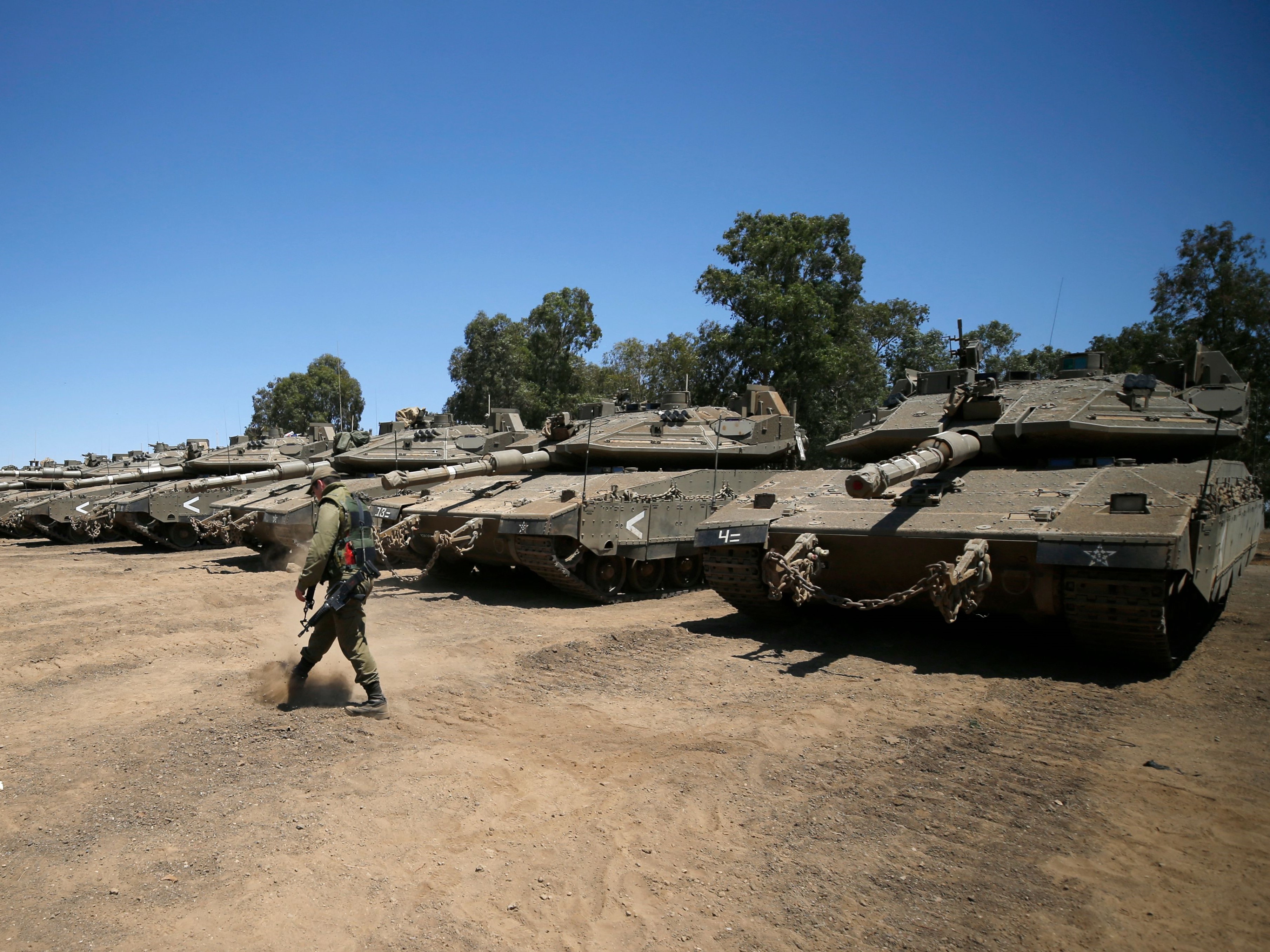 Tentara Israel berjalan melewati tank tempur Merkava, selama latihan militer di dekat Moshav dari Alonei Habashan, Dataran Tinggi Golan.