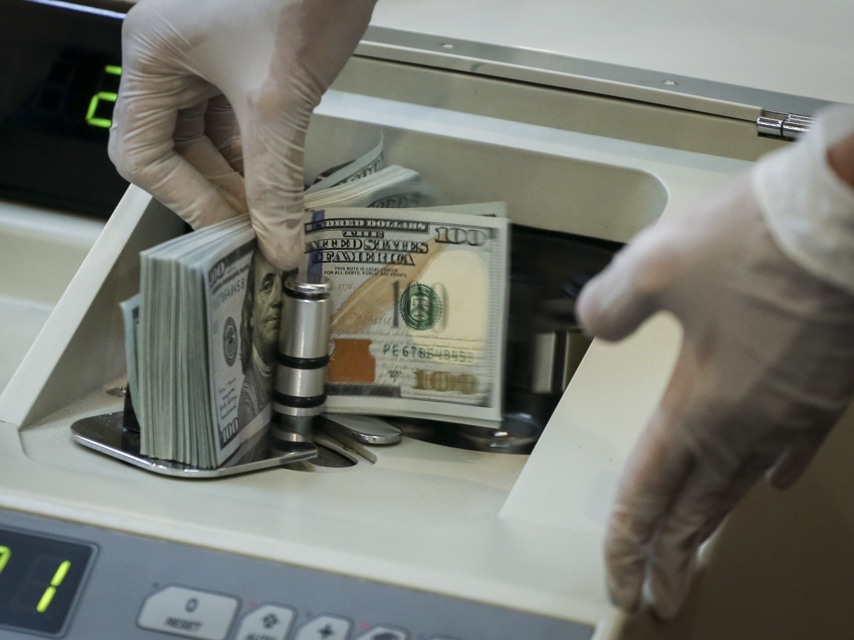 Petugas menghitung uang dolar AS di BNI KC Mega Kuningan, Jakarta.