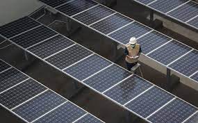Ilustrasi: Petugas membersihkan atap panel surya yang terpasang di atas gedung Dirjen Ketenagalistrikan kementerian ESDM  