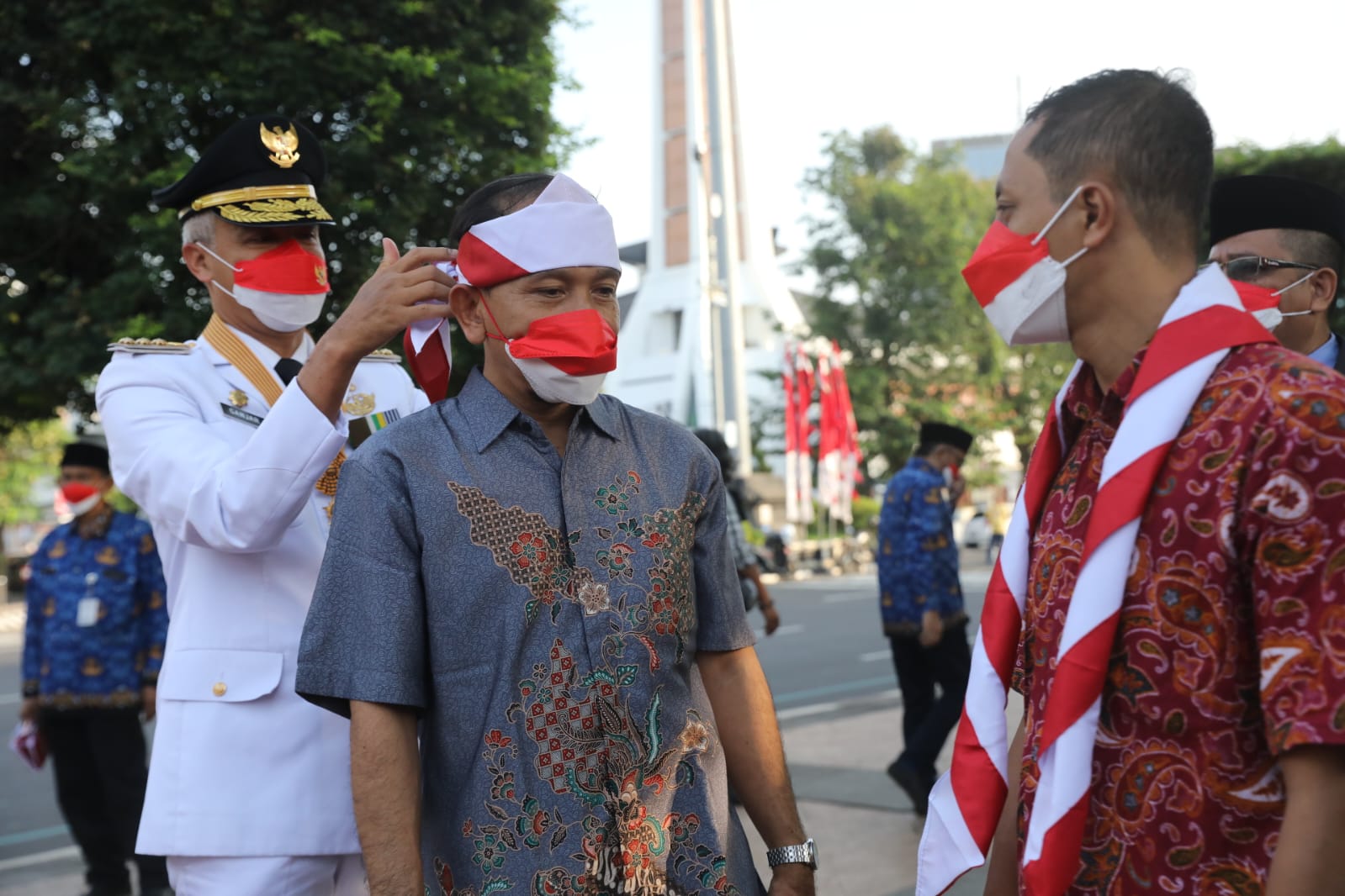 Gubernur Jateng Ganjar Pranowo menyematkan hasduk merah putih di kepala Joko Priyono, salah seorang eks napiter sesaat sebelum upacara.