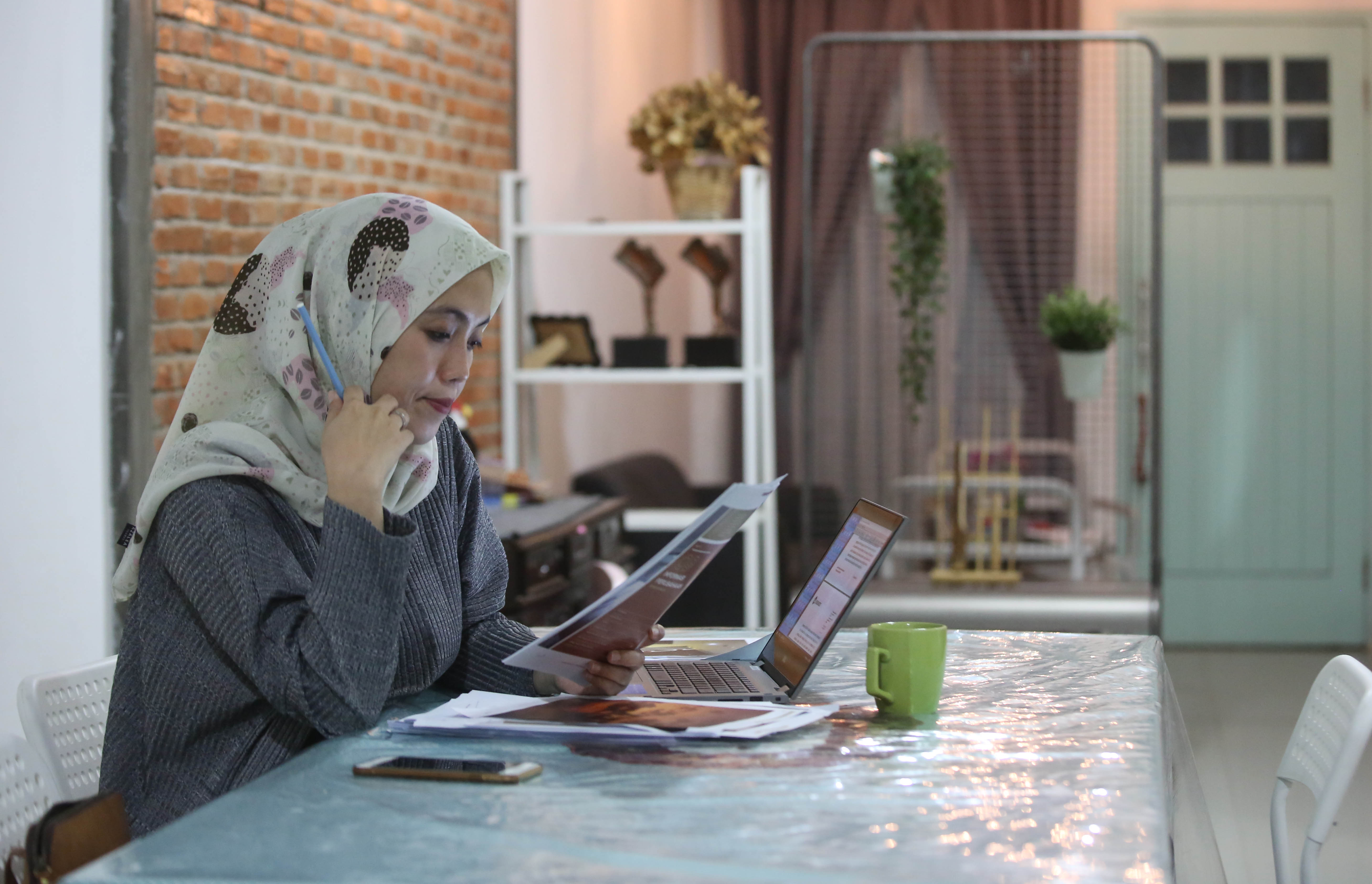 Afika, salah satu pegawai perusahaan swasta menyelesaikan pekerjaan di rumah, Jakarta.