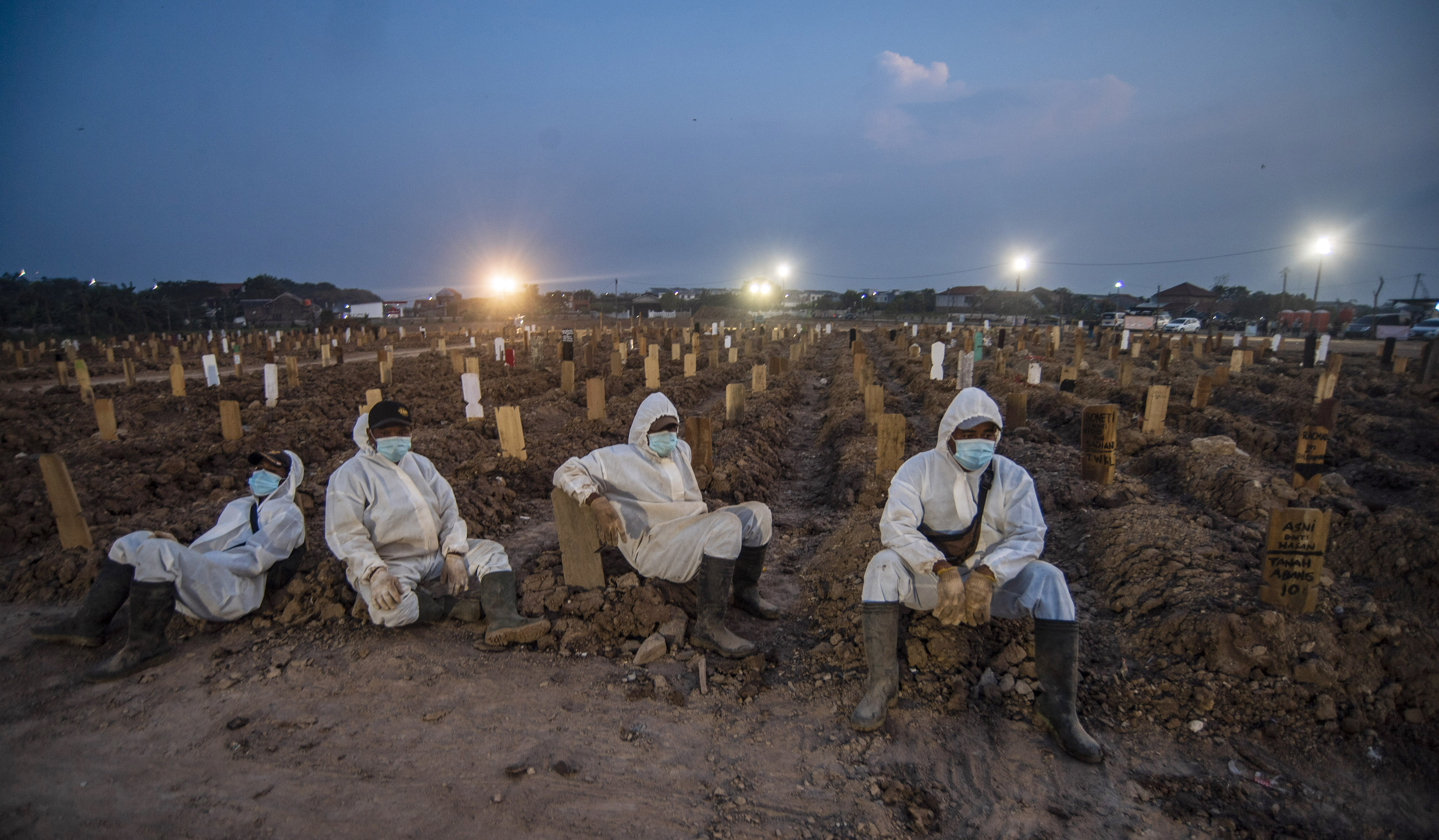  REKOR ANGKA KEMATIAN-19: Petugas beristirahat usai memakamkan sejumlah jenazah dengan prokes di TPU Rorotan, Jakarta, Minggu (4/7/2021)