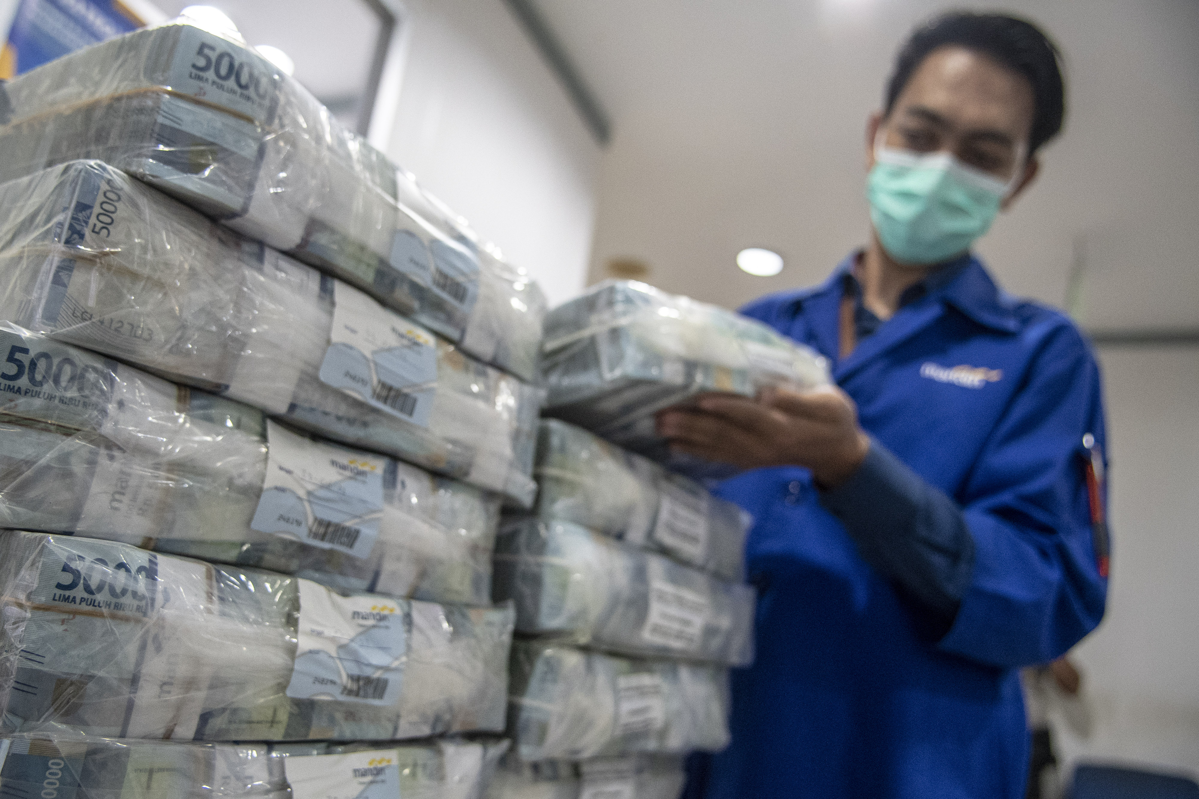 Petugas menyusun tumpukan uang di Cash Pooling Bank Mandiri, Jakarta.