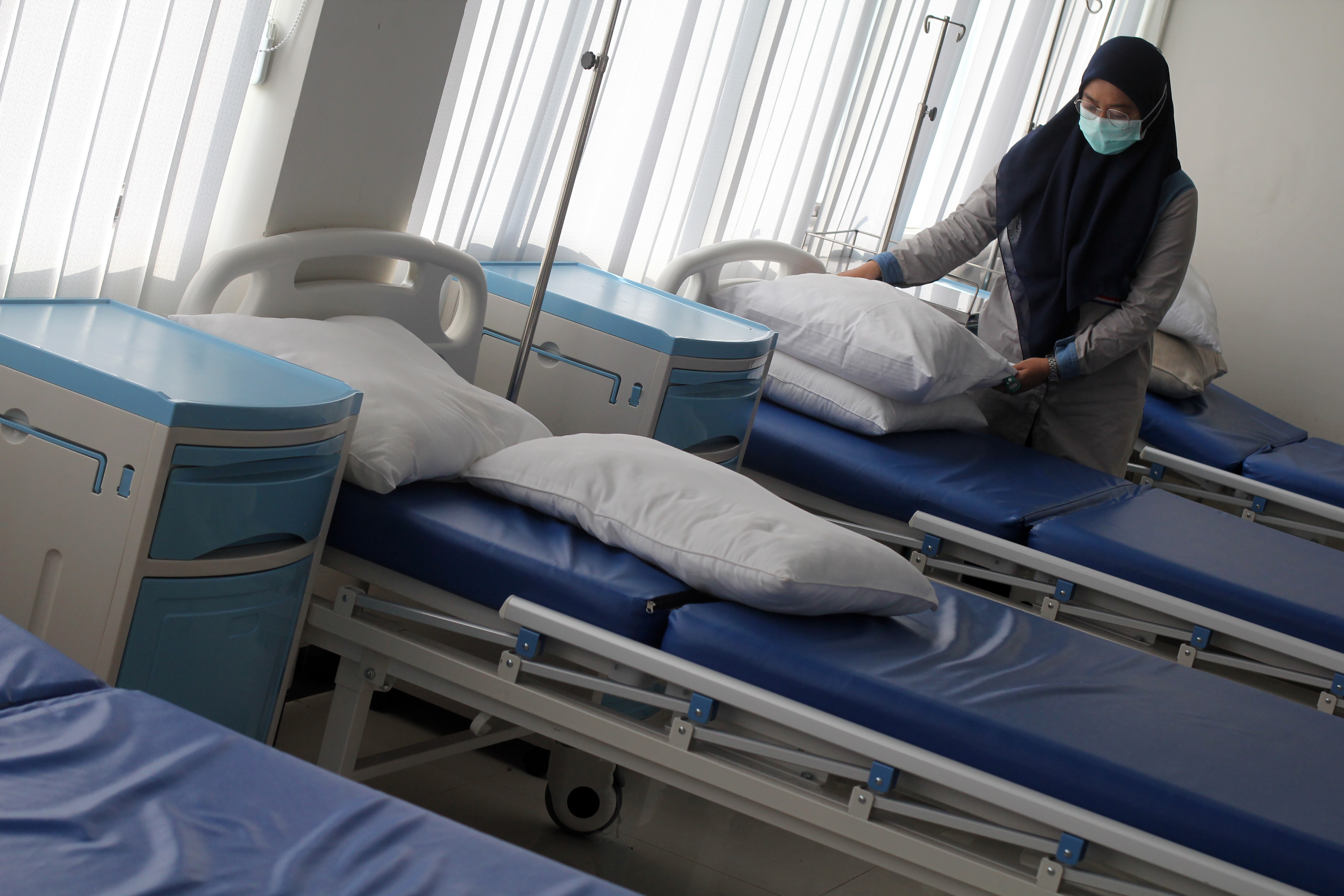 Petugas merapikan bantal di rumah sakit darurat.