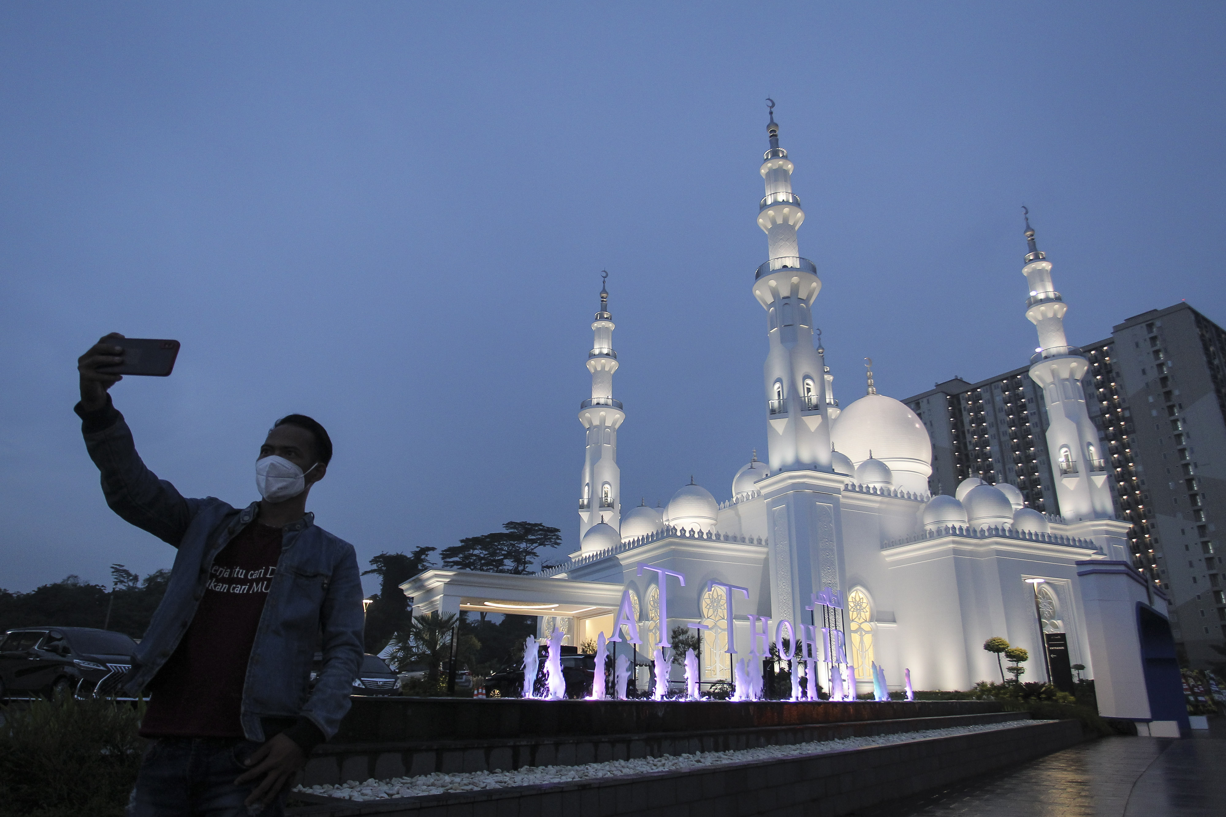 Seorang warga melakukan swafoto dengan latar belakang Masjid At-Thohir Cimanggis, Depok, Jawa Barat, Rabu (9/3)