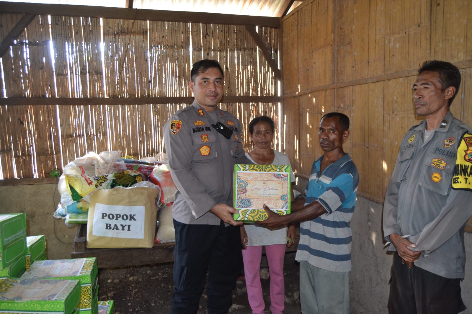 Kapolres Flotim AKBP I Gede Ngurah Joni Mahardika (kiri) menyerahkan bantuan sembako ke warga Desa Lamatutu