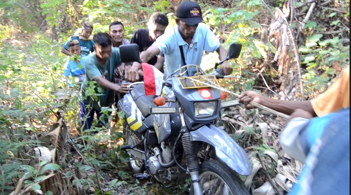 Warga menarik sepeda motor milik Aiptu Yoseph yang tidak bisa melewati jalan yang terjal.