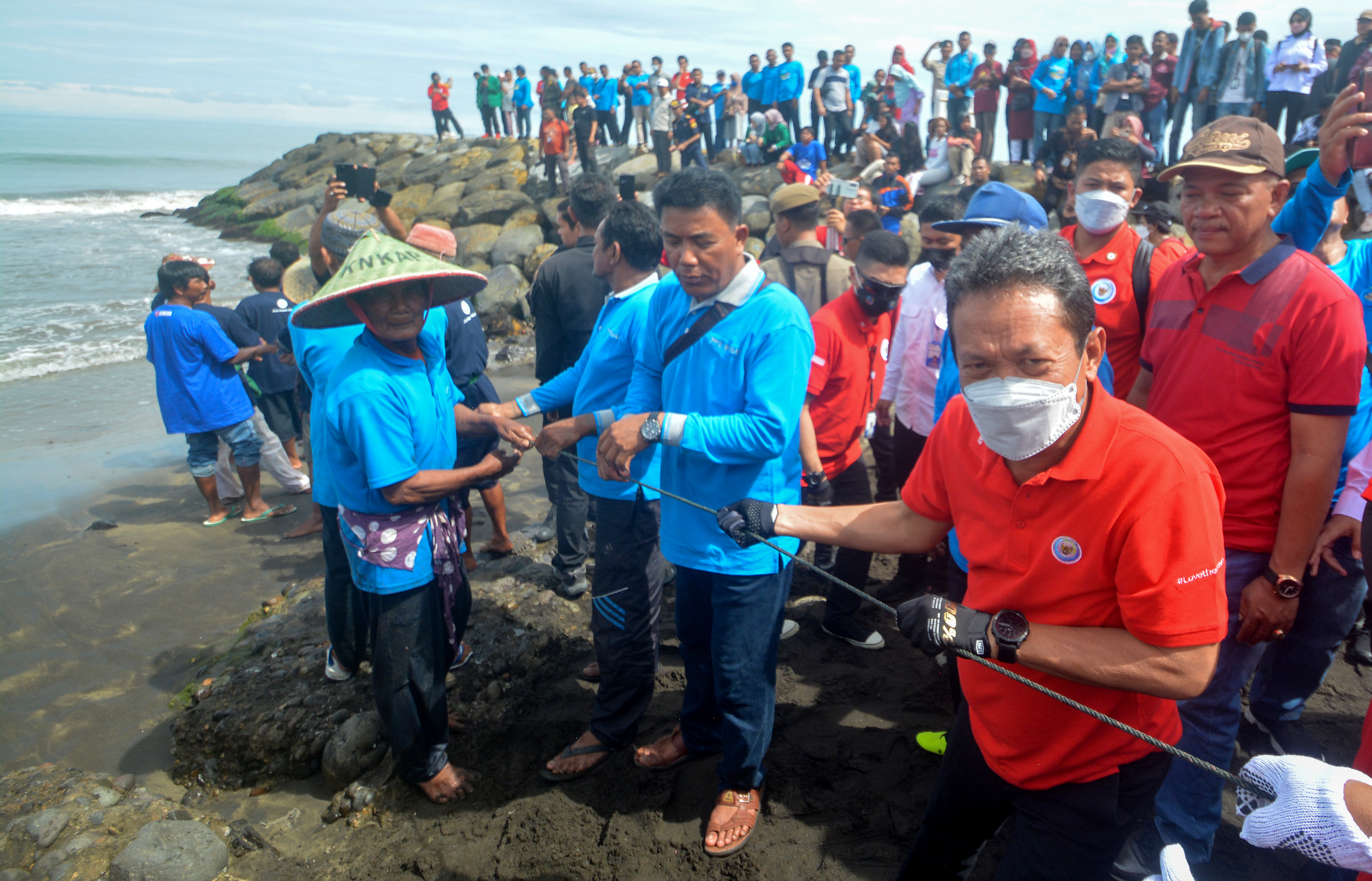 Menteri KP Sakti Wahyu Trenggono mencoba tradisi Maelo Pukek usai peresmian Kampung Elo Pukek di Purus, Padang, Sumbar, Minggu (21/8).