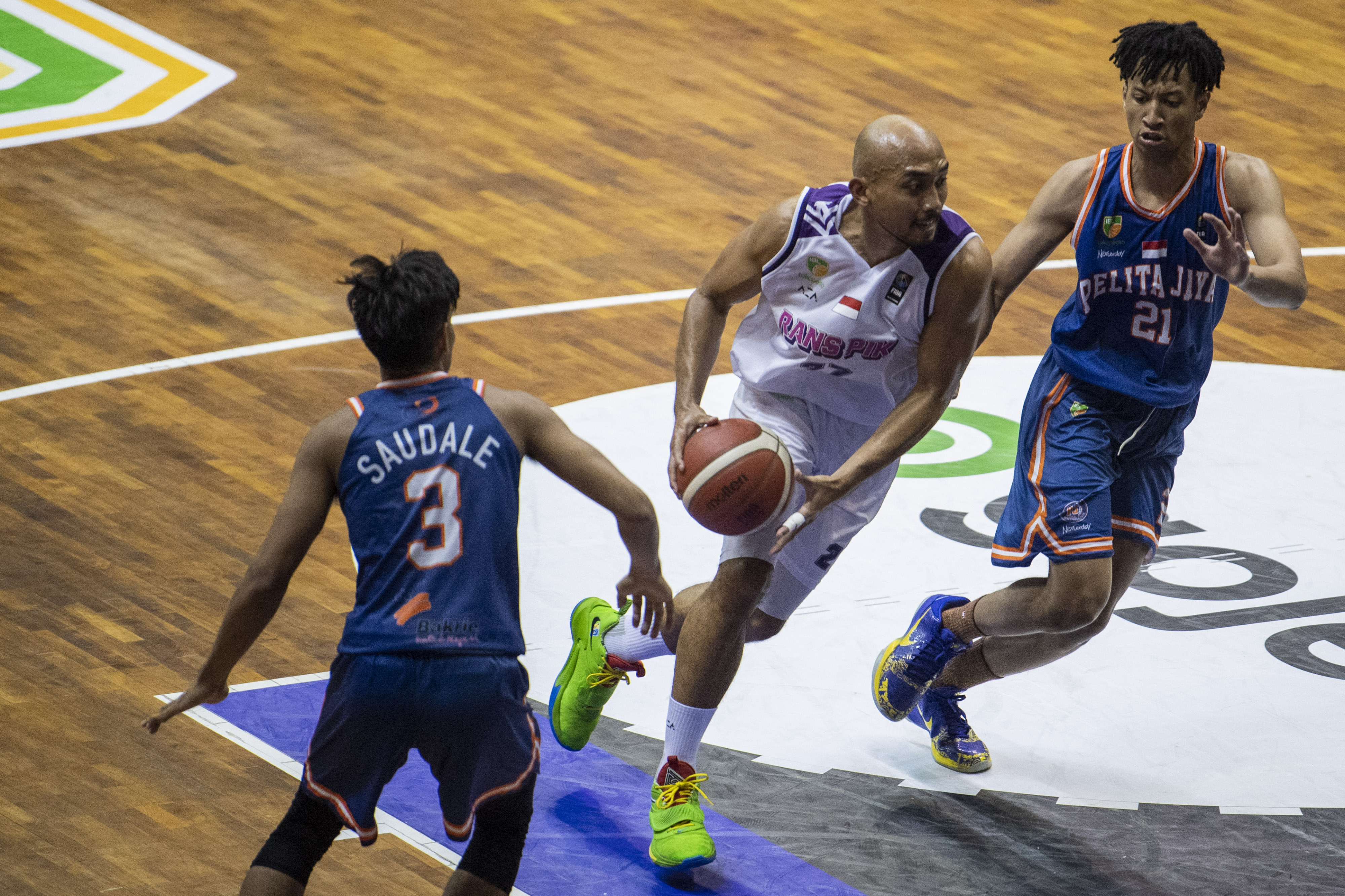 Pebasket Pelita Jaya berusaha menghadang laju pebasket RANS PIK dalam laga IBL 2022.