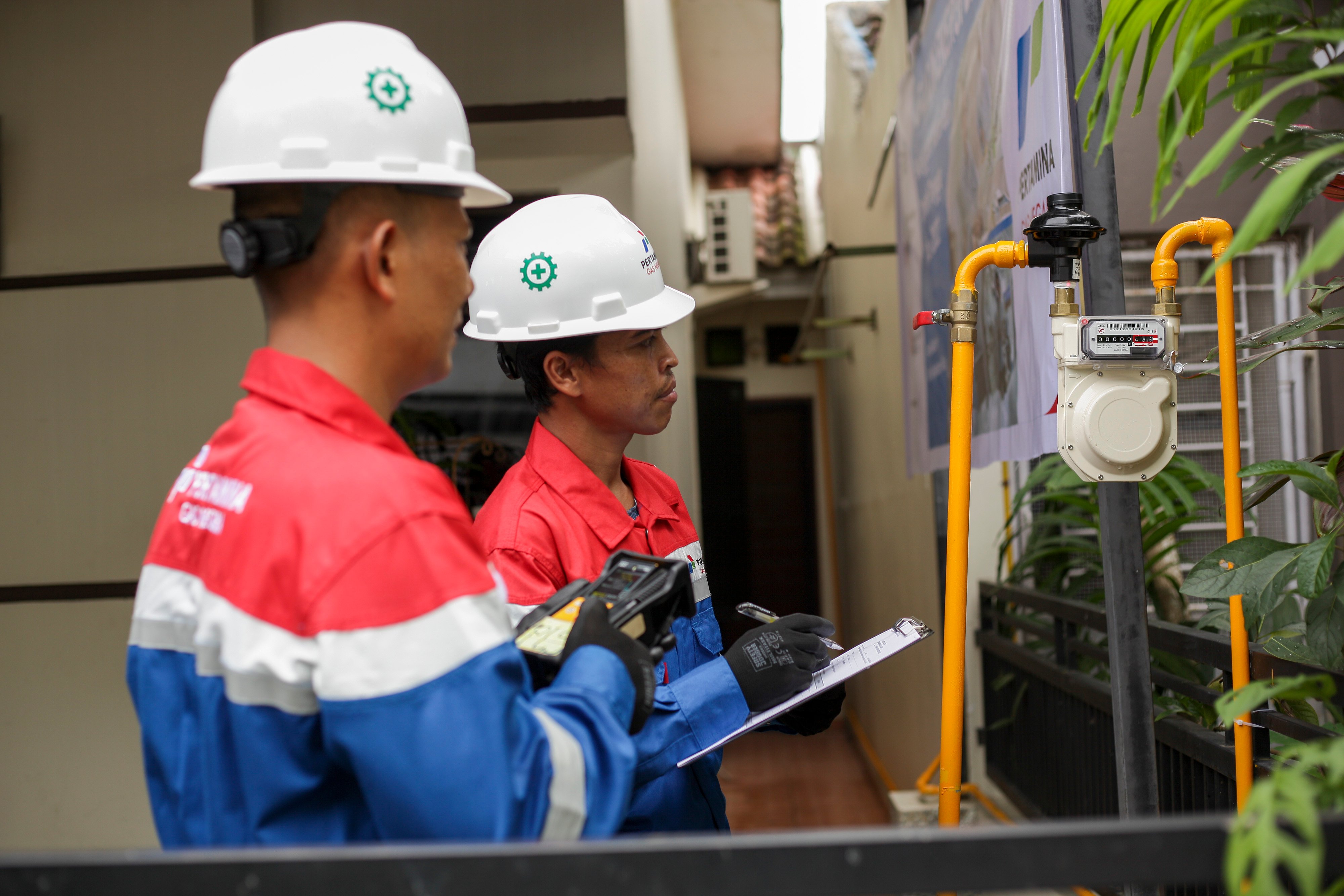 Petugas Perusahaan Gas Negara memeriksa meteran gas di salah satu rumah warga.