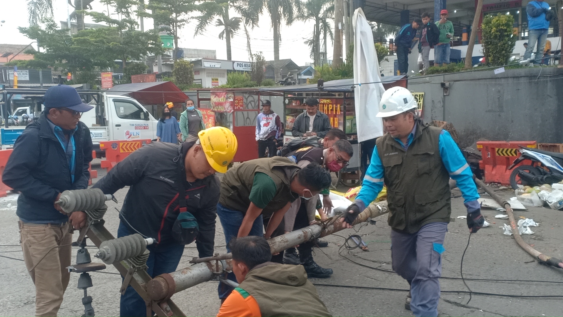 Petugas PLN mengevakuasi tiang listrik yang roboh di Jalan Kiwi, Lembang, Kabupaten Bandung Barat, Selasa (2/8) sore.