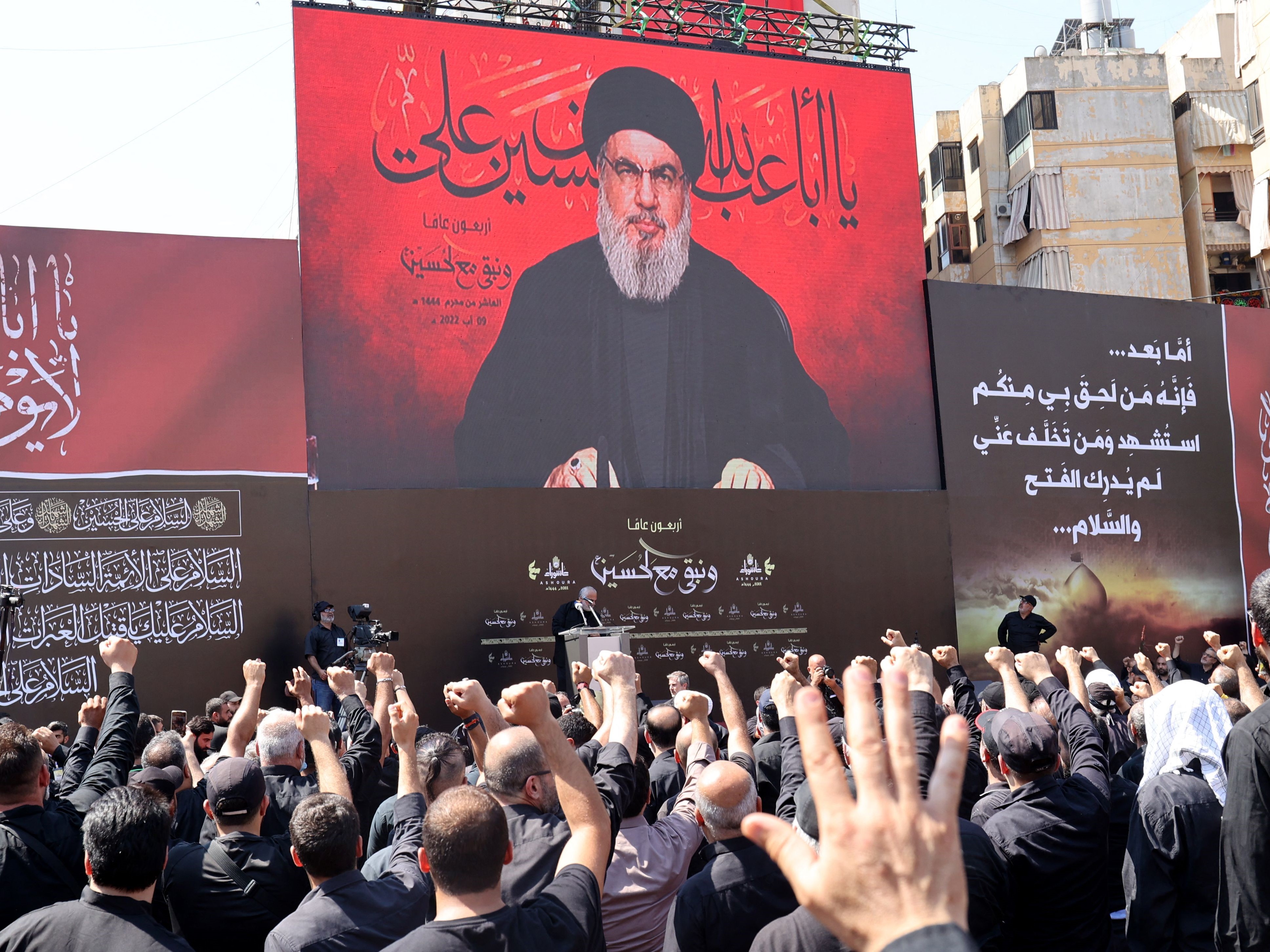 Pendukung Hizbullah Libanon menyambut pemimpin kelompok itu Hassan Nasrallah saat berbicara kepada mereka melalui layar raksasa.