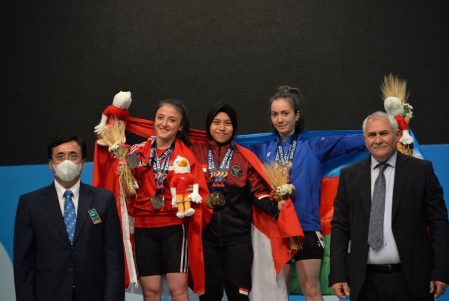 Lifter Indonesia Siti Nafisatul Hariroh (tengah) meraih medali emas di ajang ISG 2022.