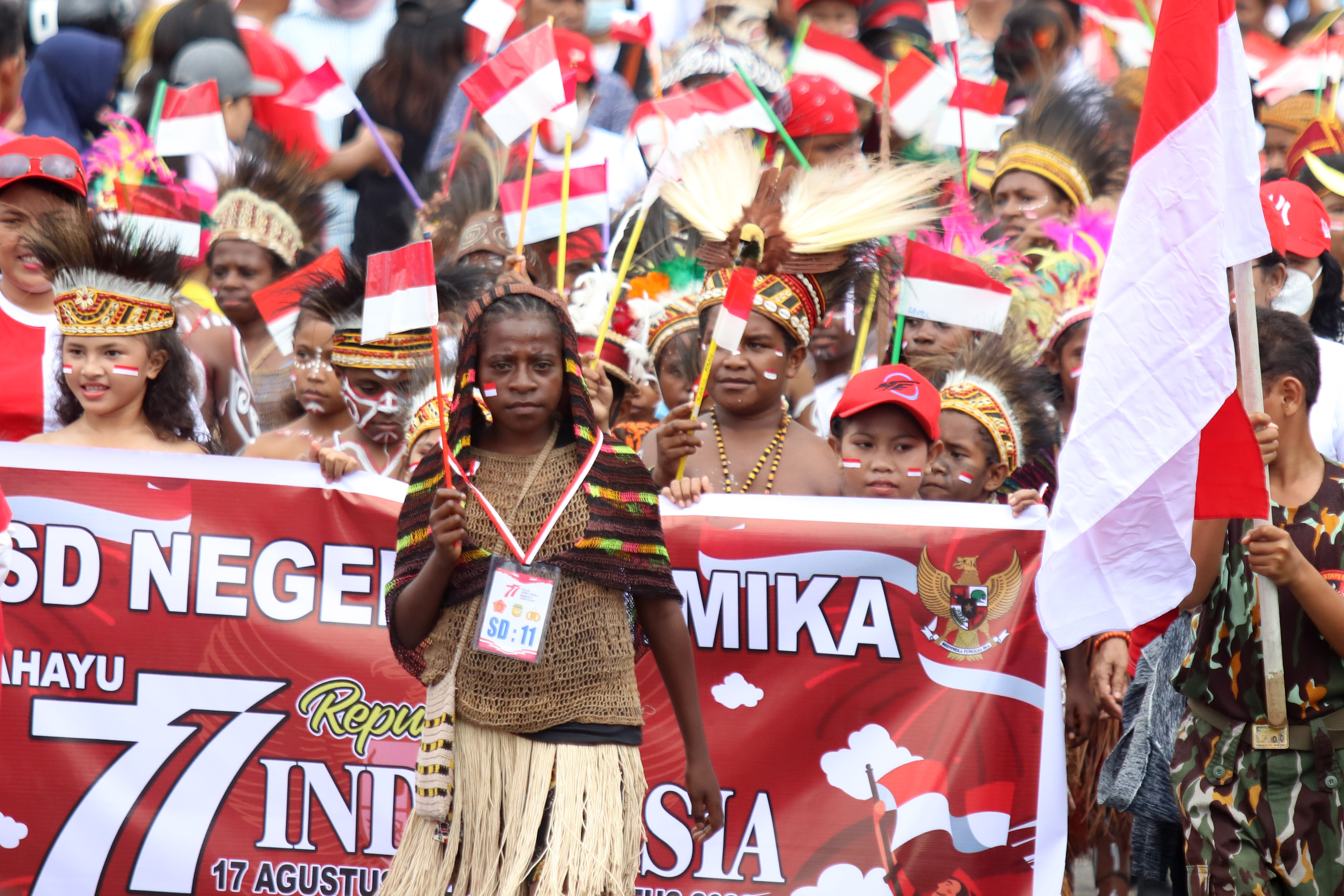 Peserta yang mengenakan pakaian adat Papua mengikuti karnaval di Mimika, Papua Tengah.