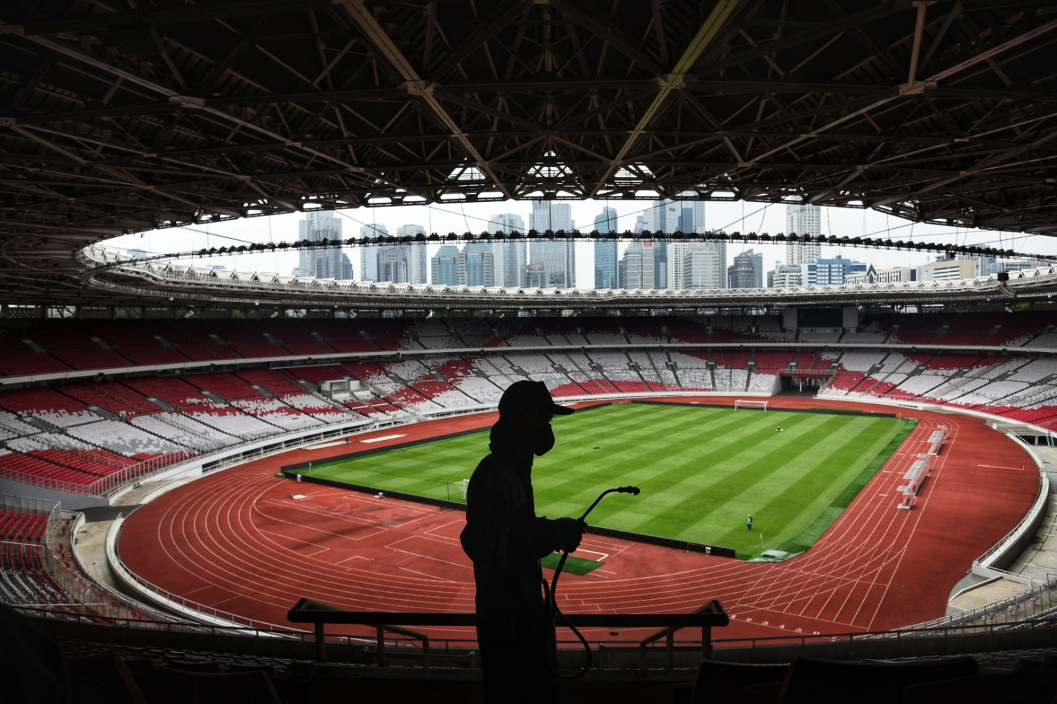 Petugas melakukan penyemprotan disinfektan di area Stadion Gelora Bung Karno, Jakarta.