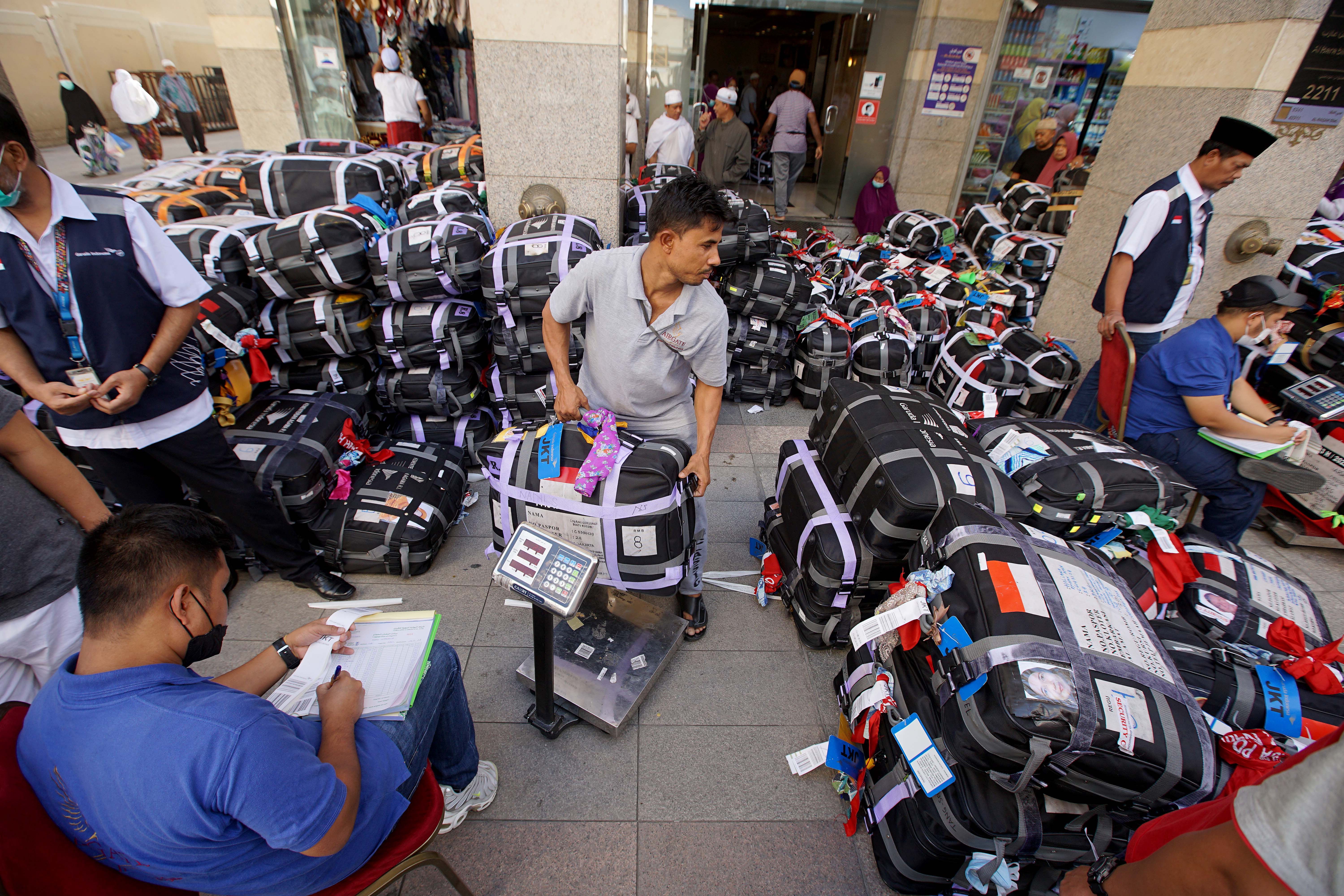 Pekerja dari maskapai penerbangan menimbang sejumlah koper milik jemaah haji Indonesia di Madinah, Arab Saudi.
