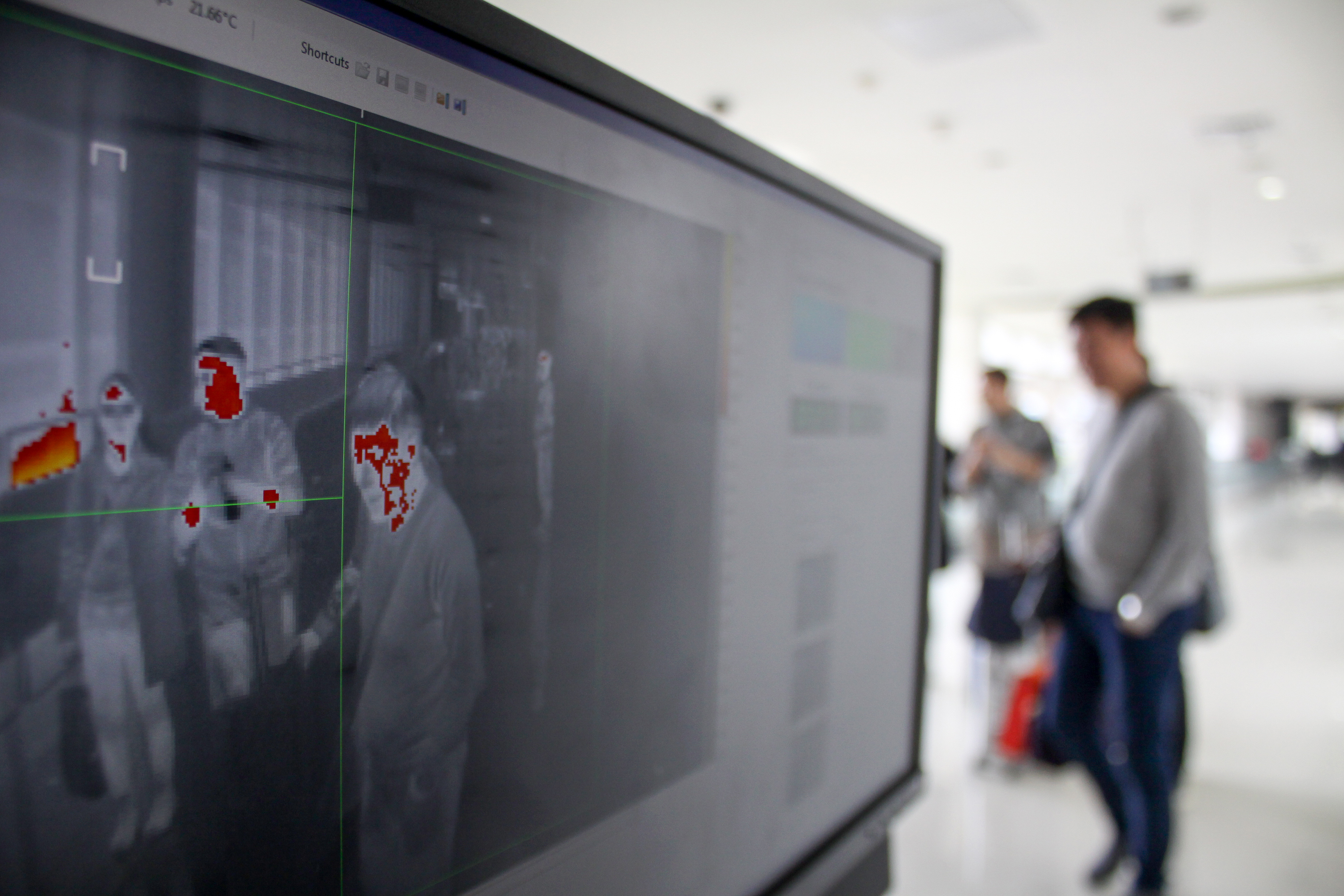 Penumpang pesawat melintasi alat pendeteksi suhu tubuh (thermal scanner) saat tiba di terminal 2 Bandara Juanda Surabaya di Sidoarjo.