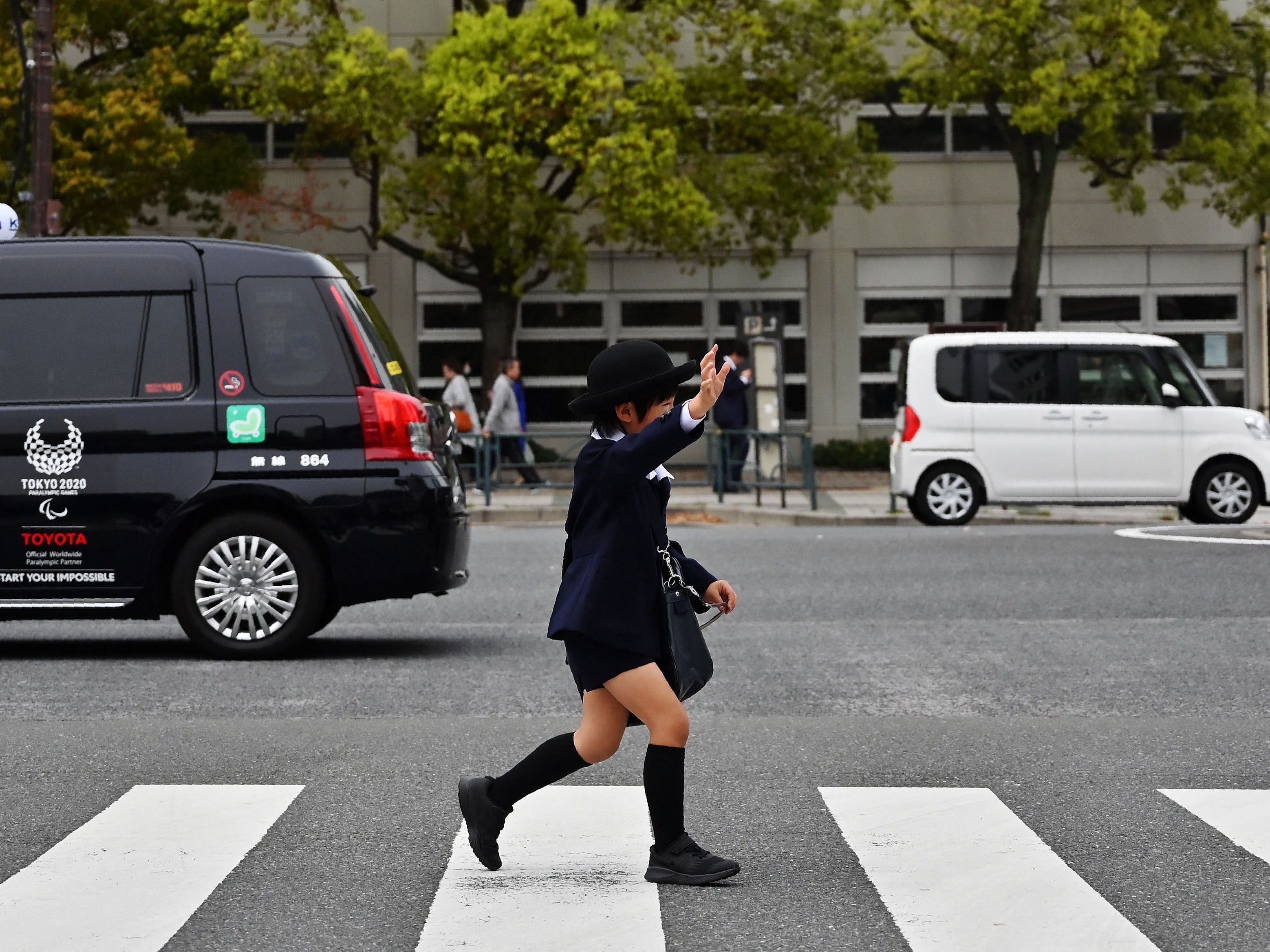 Seorang anak sekolah menyeberang jalan di lingkungan Toyosu Tokyo.