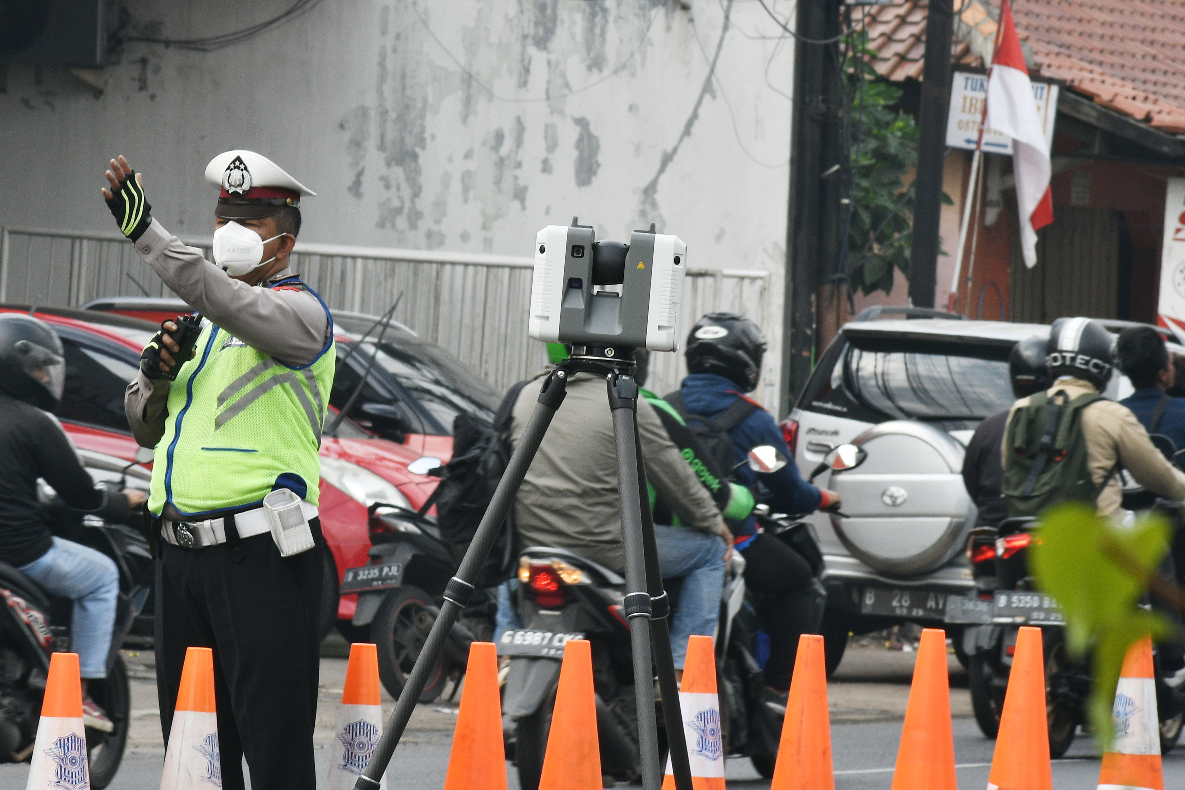 Polisi mengatur lalu lintas saat olah TKP kecelakaan truk trailer menggunakan alat 3D Lasser Scanner di Kranji, Kamis (1/9).