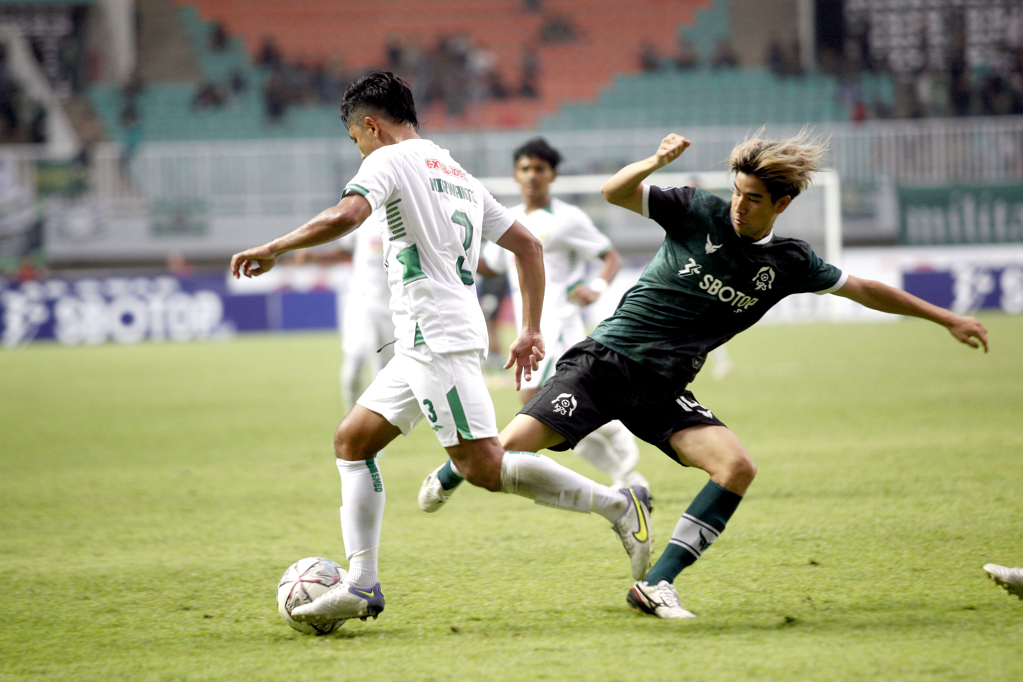 Pesepak bola Persikabo 1973 Tomoki Wada (kanan) mencoba merebut bola dari pesepak bola PSS Sleman Ibrahim Sanjaya (kiri) dalam lanjutan BRI 