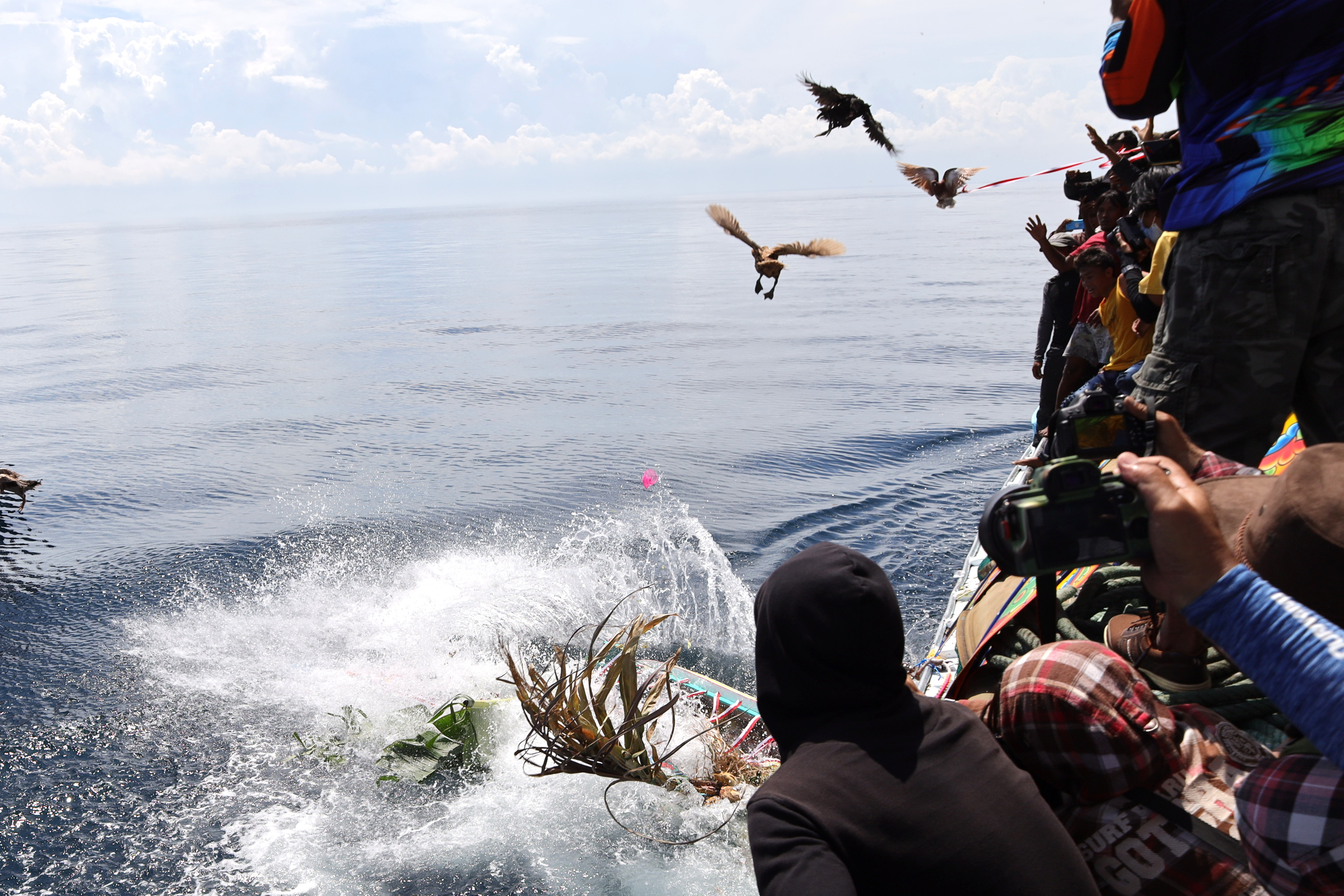 Warga melarung gitik sesaji di perairan Sembulungan pada acara Ritual Petik Laut Muncar, Banyuwangi, Jawa Timur, Sabtu (13/8).