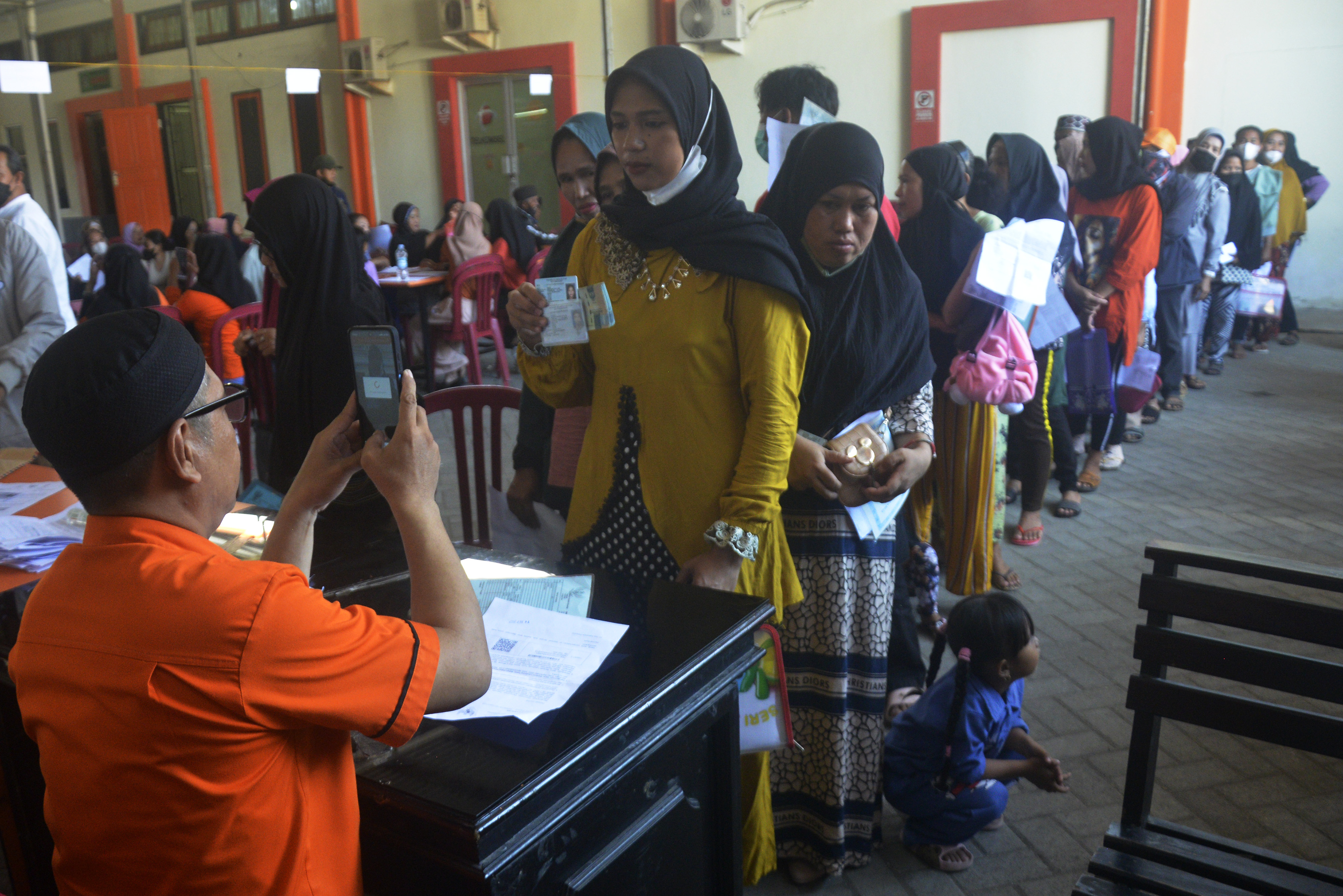 Petugas memotret identitas penerima bansos sebagai tanda bukti.