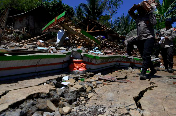 Sejumlah polisi membantu warga membersihkan puing bangunan yang rusak akibat gempa di Desa Kaliuling, Lumajang, Jawa Timur,Senin (12/4/2021)