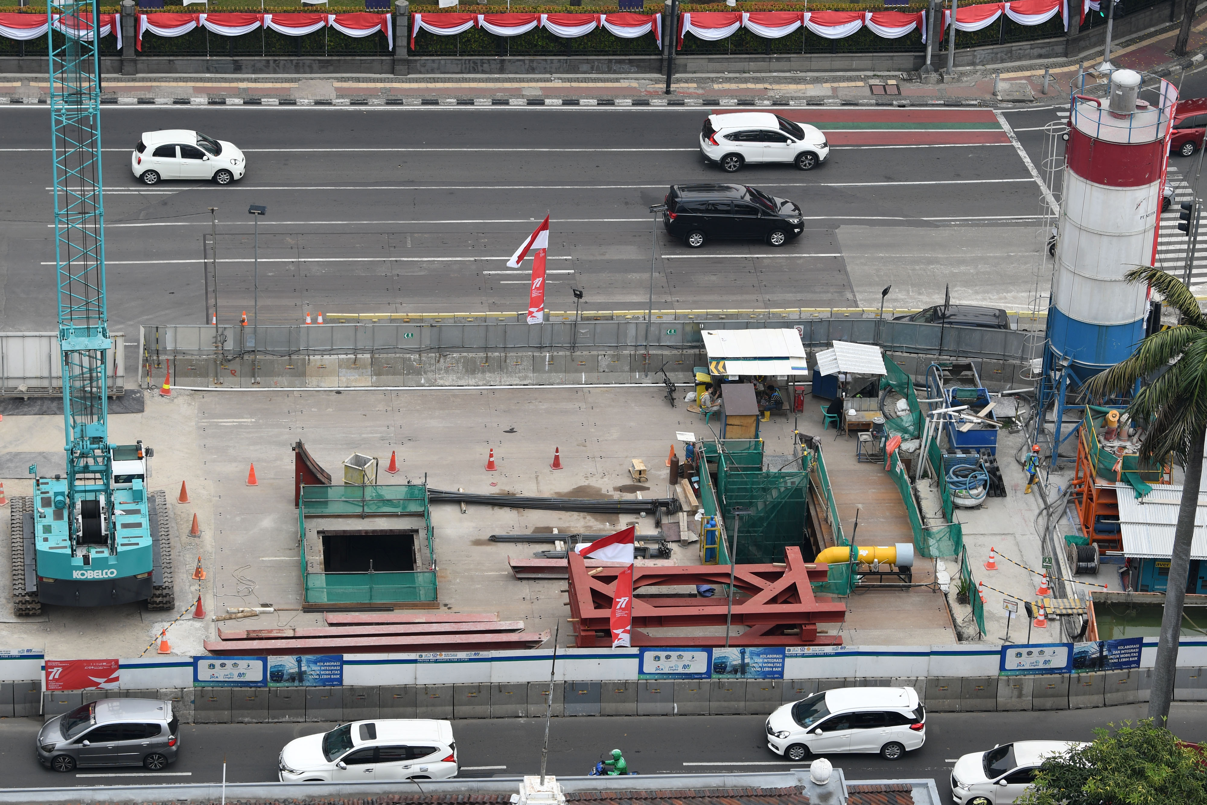 Sejumlah kendaraan melintas di samping proyek pembangunan jalur kereta Moda Raya Terpadu (MRT) Jakarta Fase 2 di Jalan MH Thamrin, Jakarta