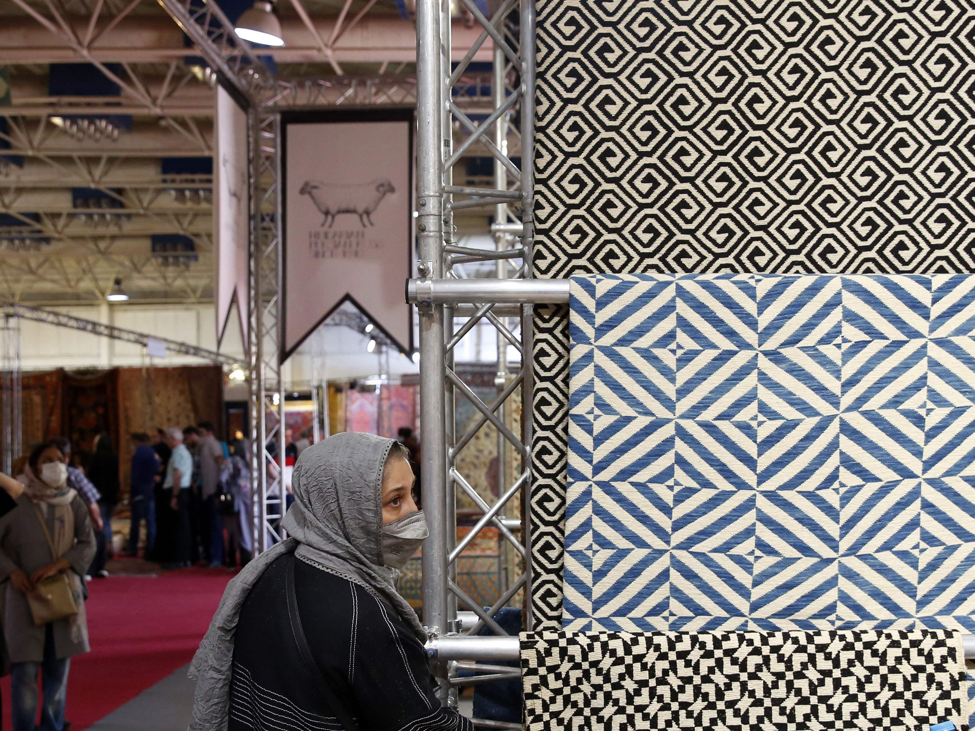 Orang-orang melihat pajangan karpet wol Azerbaijan modern dengan desain geometris tradisional yang berasal dari abad ke-17 di Iran.