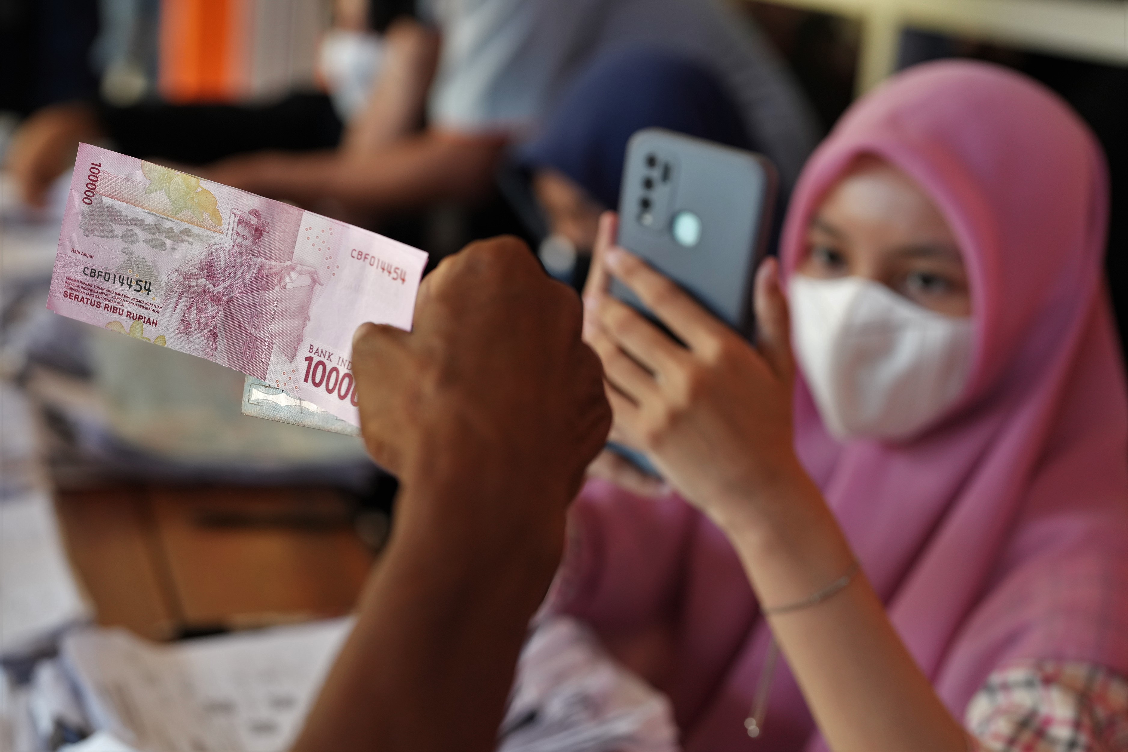 Petugas merekam penyerahan BLT BBM kepada warga.