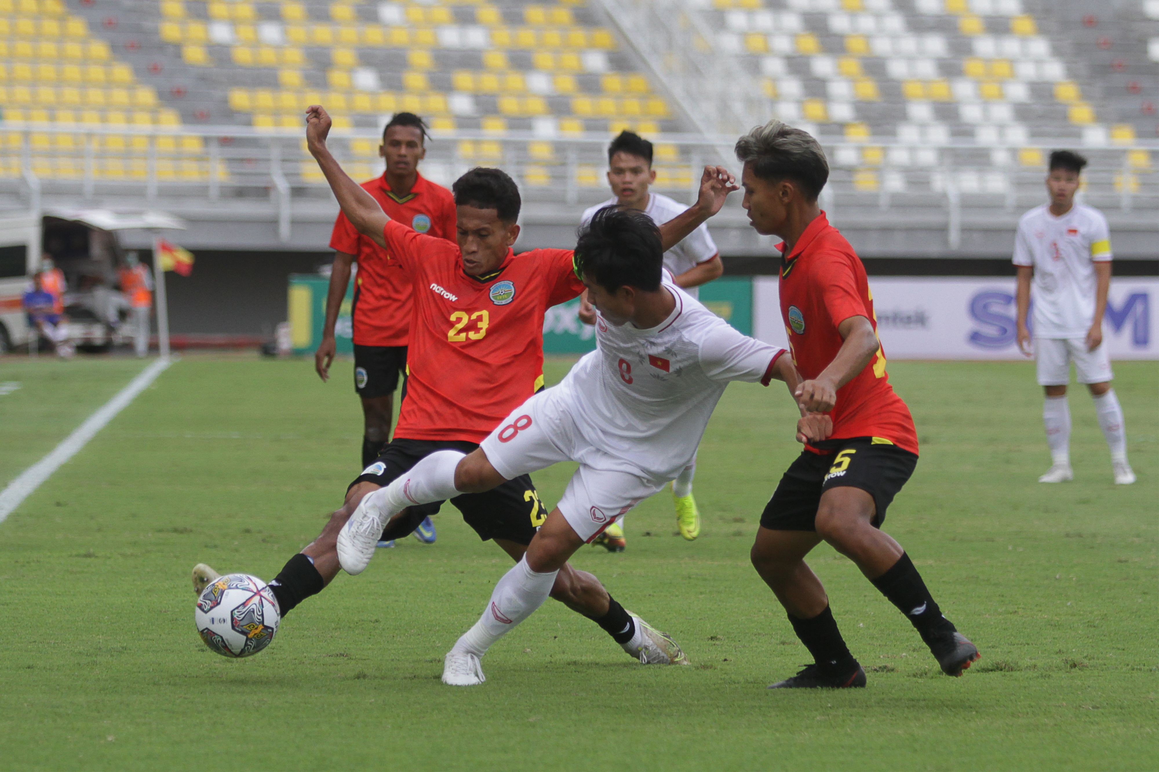 Pemain tim U-20 Vietnam Nguyen Van Tu (tengah) mencoba melewati dua pemain Timor Leste dalam laga di Surabaya, Jumat (16/9).