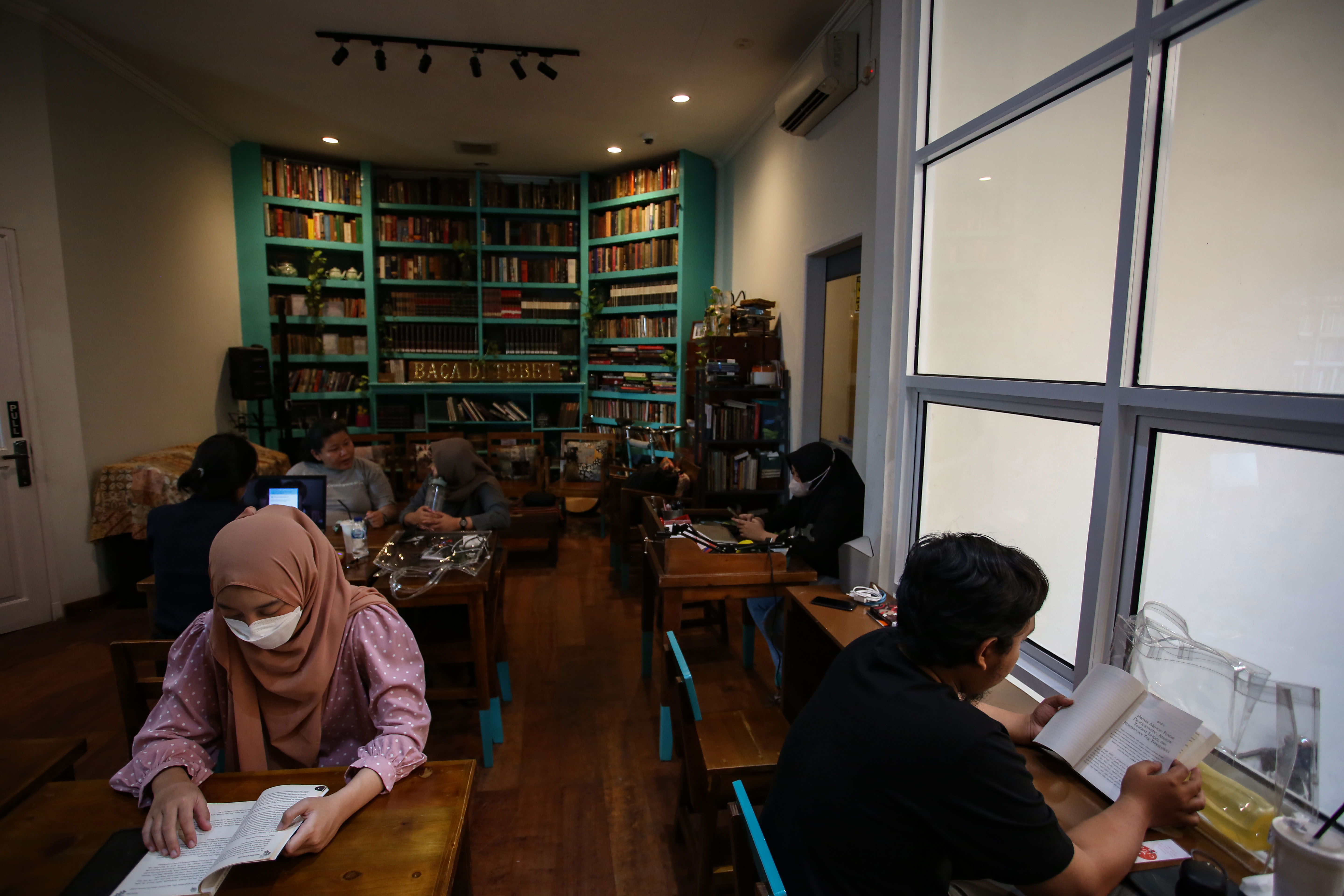 Pengunjung membaca buku di perpustakaan Baca Di Tebet, Jakarta.