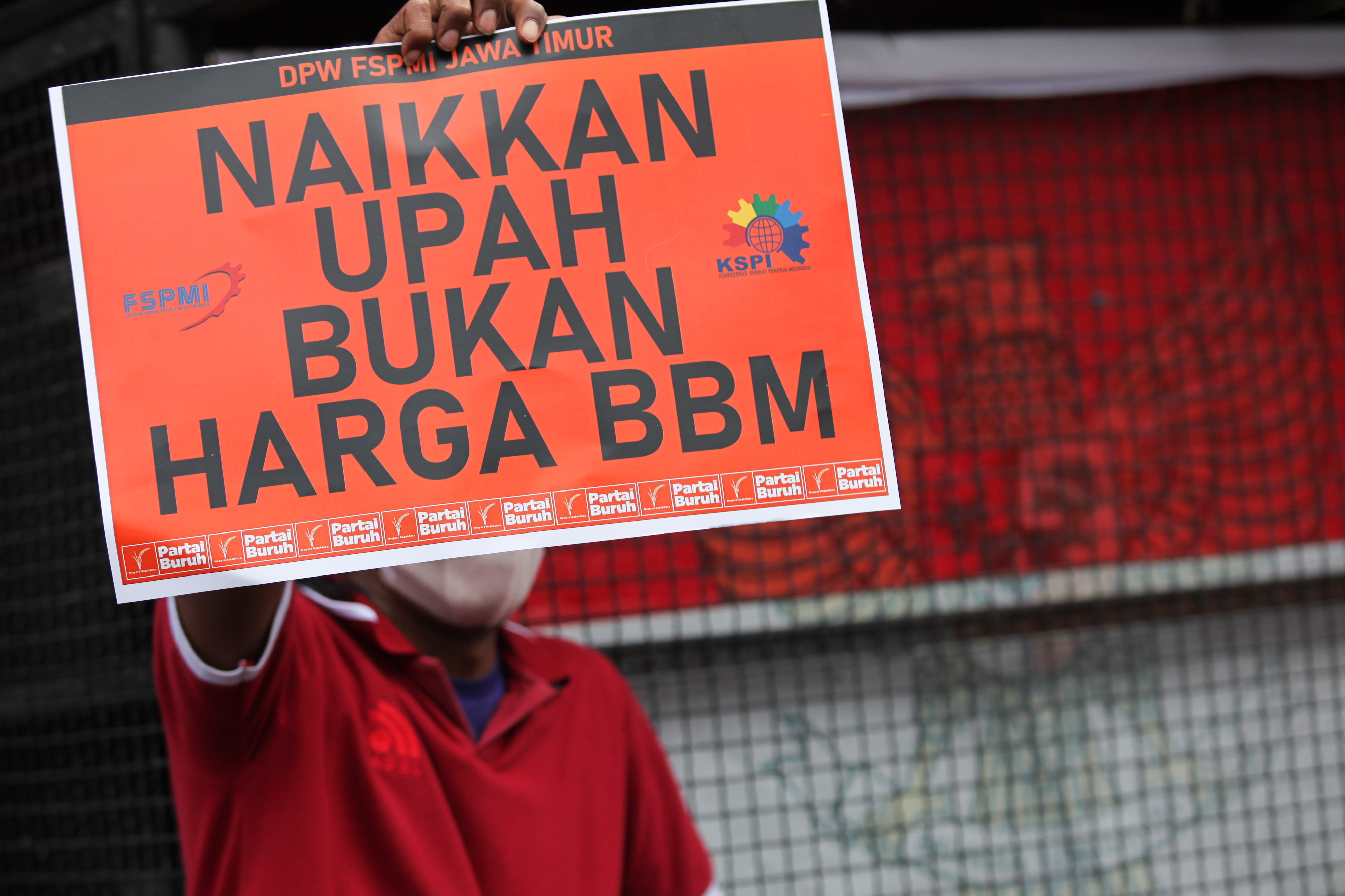Seorang buruh membentangkan poster penolakan terhadap kenaikan harga BBM.