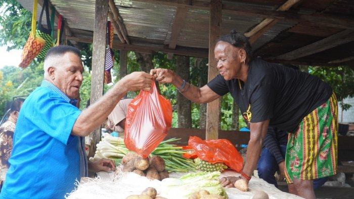  Penjabat (PJ) Gubernur Papua Barat, Paulus Waterpauw membeli sayuran dan buah-buahan dari hasil kebun di sebuah pondok Mama Papua. 