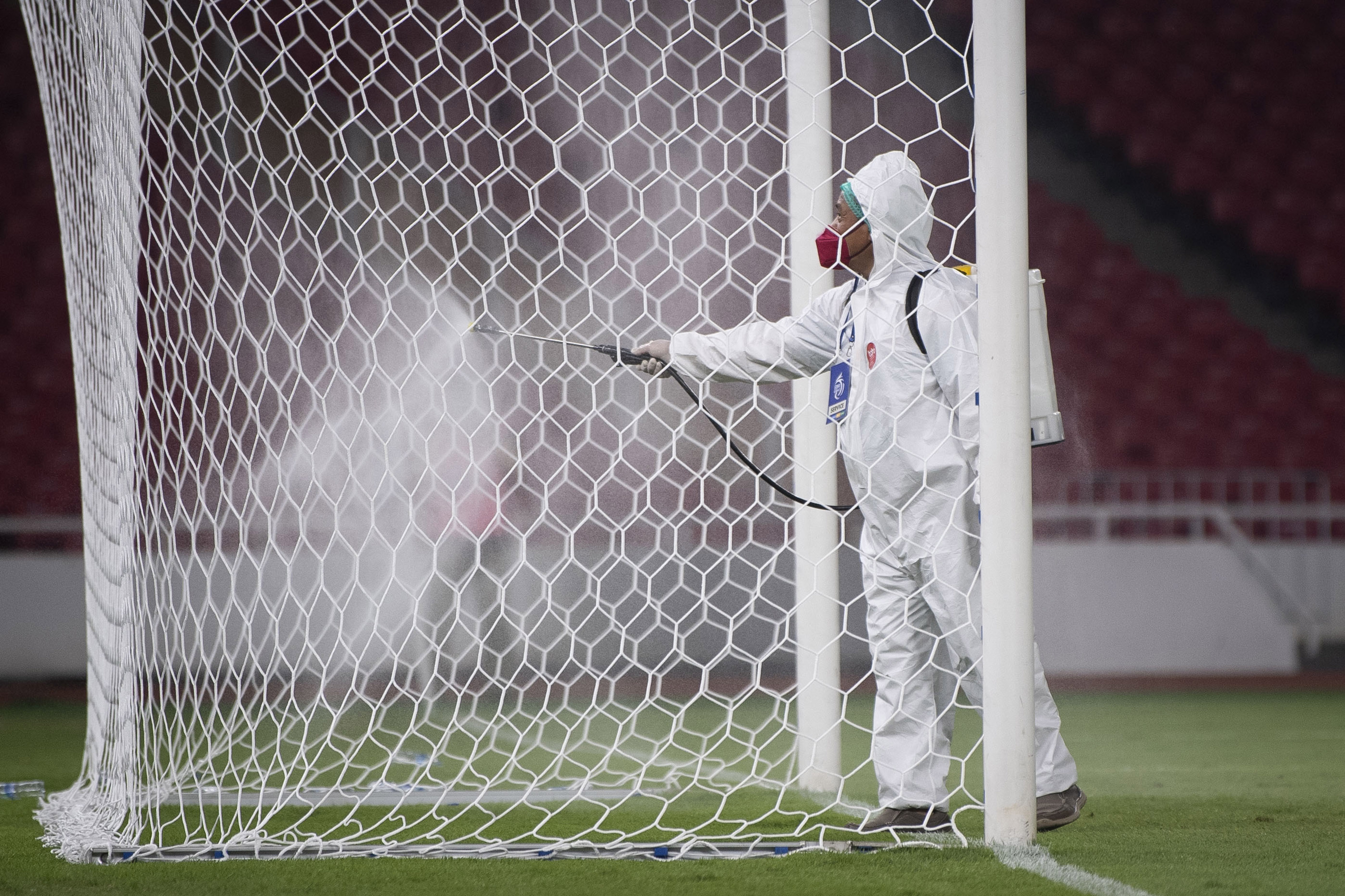 Petugas menyemprotkan cairan disinfektan pada gawang di stadion.