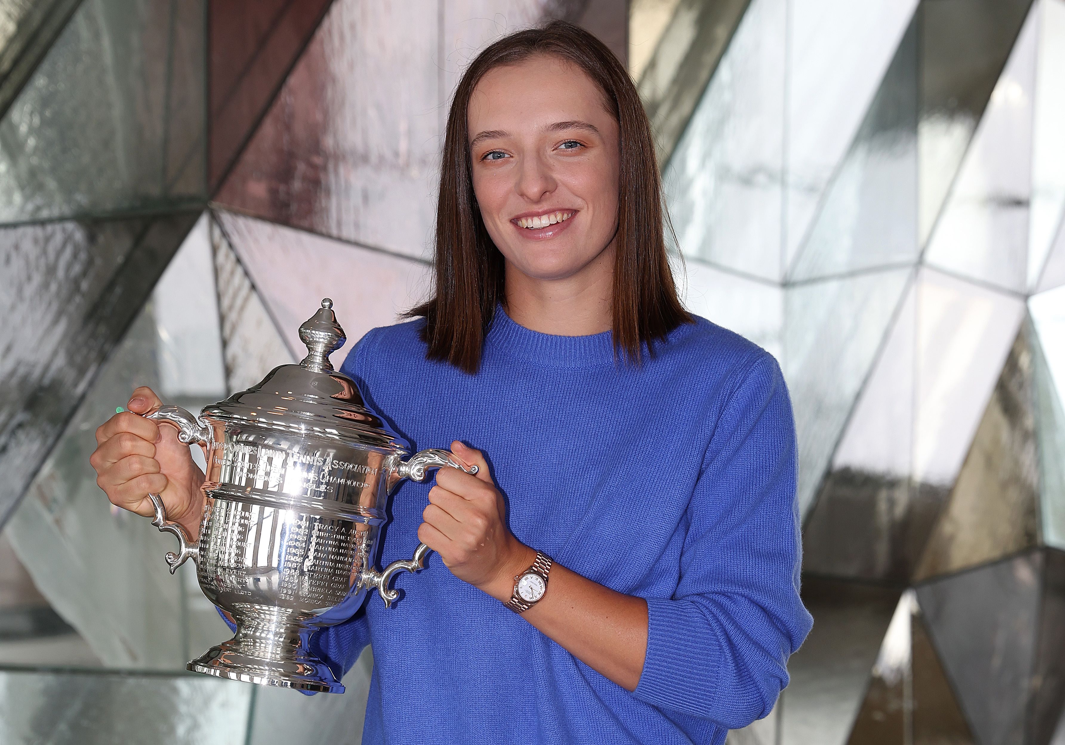 Petenis Polandia Iga Swiatek memamerkan trofi AS Terbuka yang dimenangkannya.